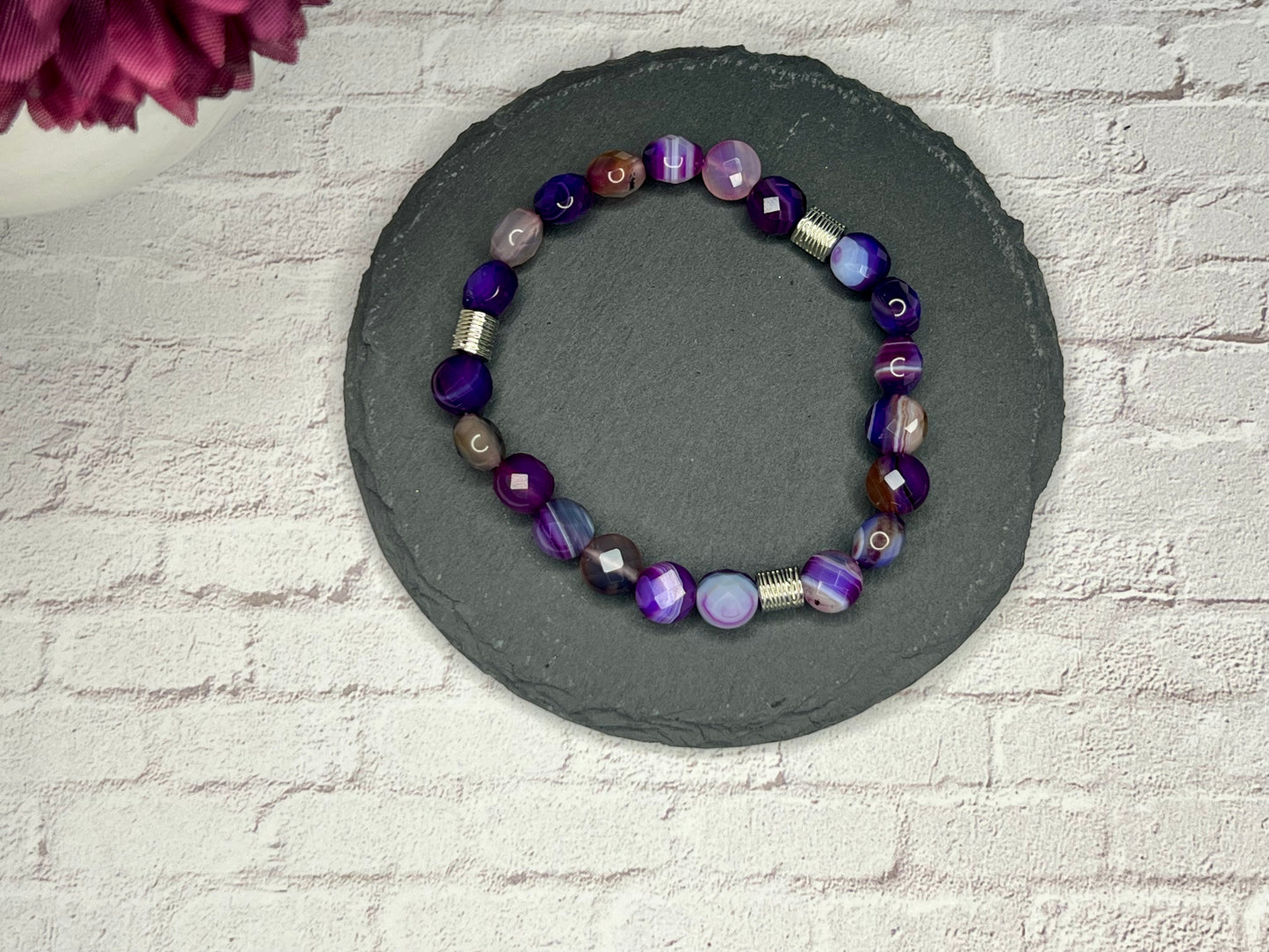 a bracelet made of glass beads on a stone circle