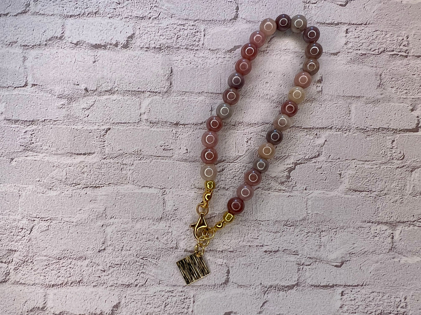 a long beaded necklace with a gold charm