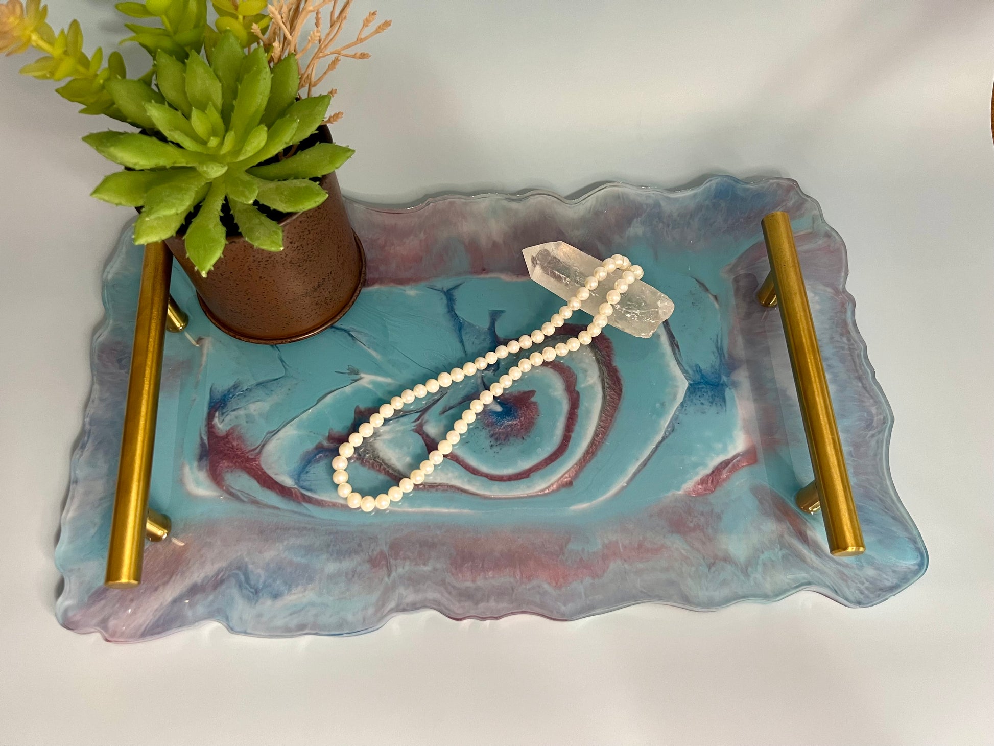 a glass tray with a pearl necklace on it