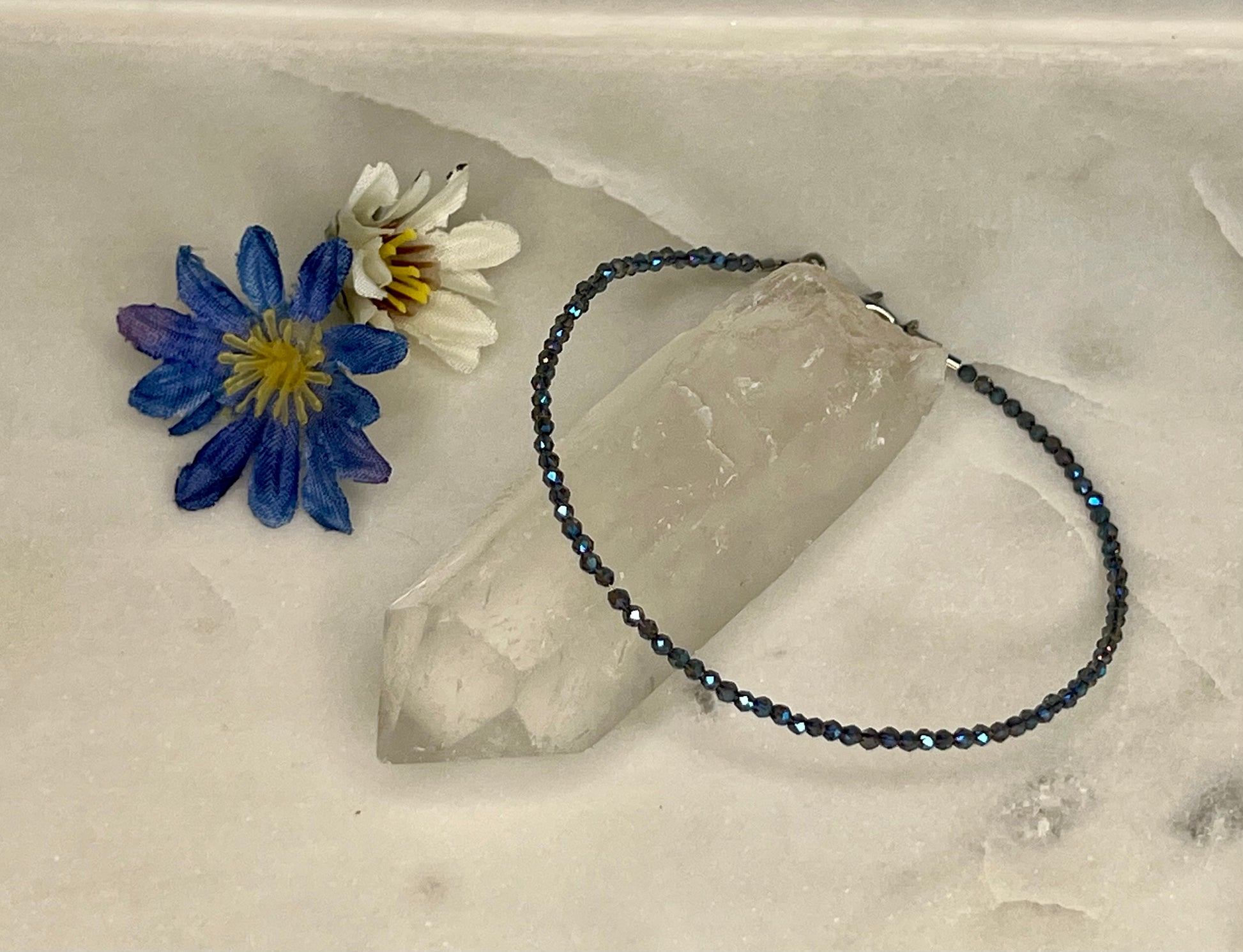 a bracelet and a flower on a rock