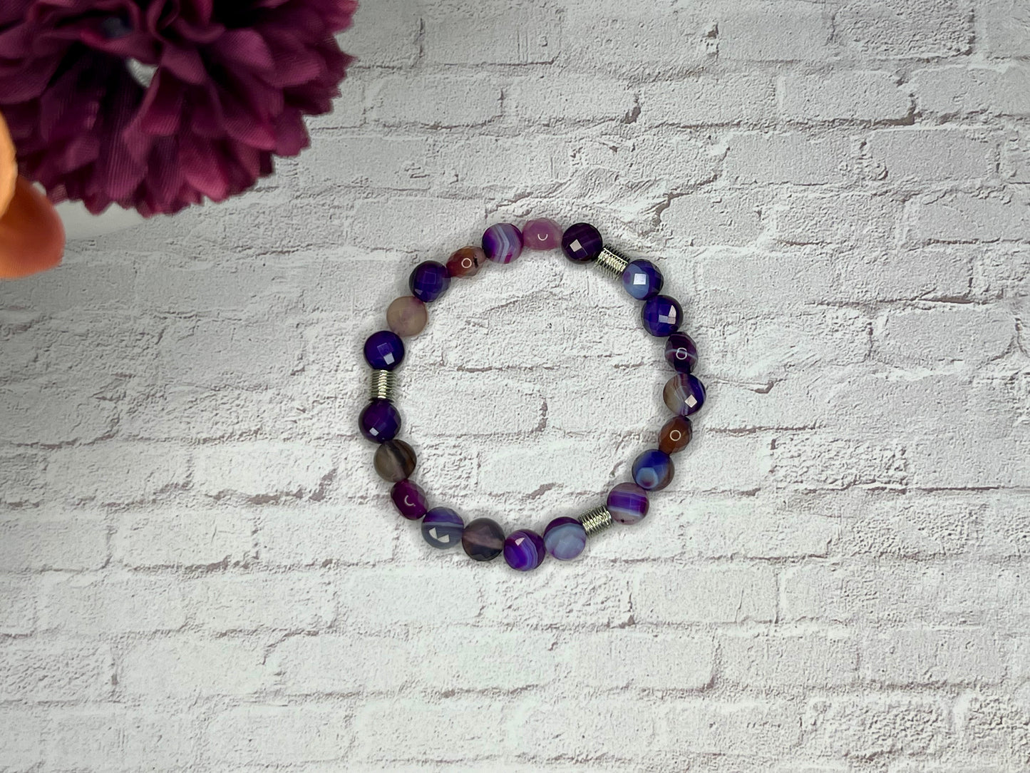 a bracelet made of glass beads on a brick wall