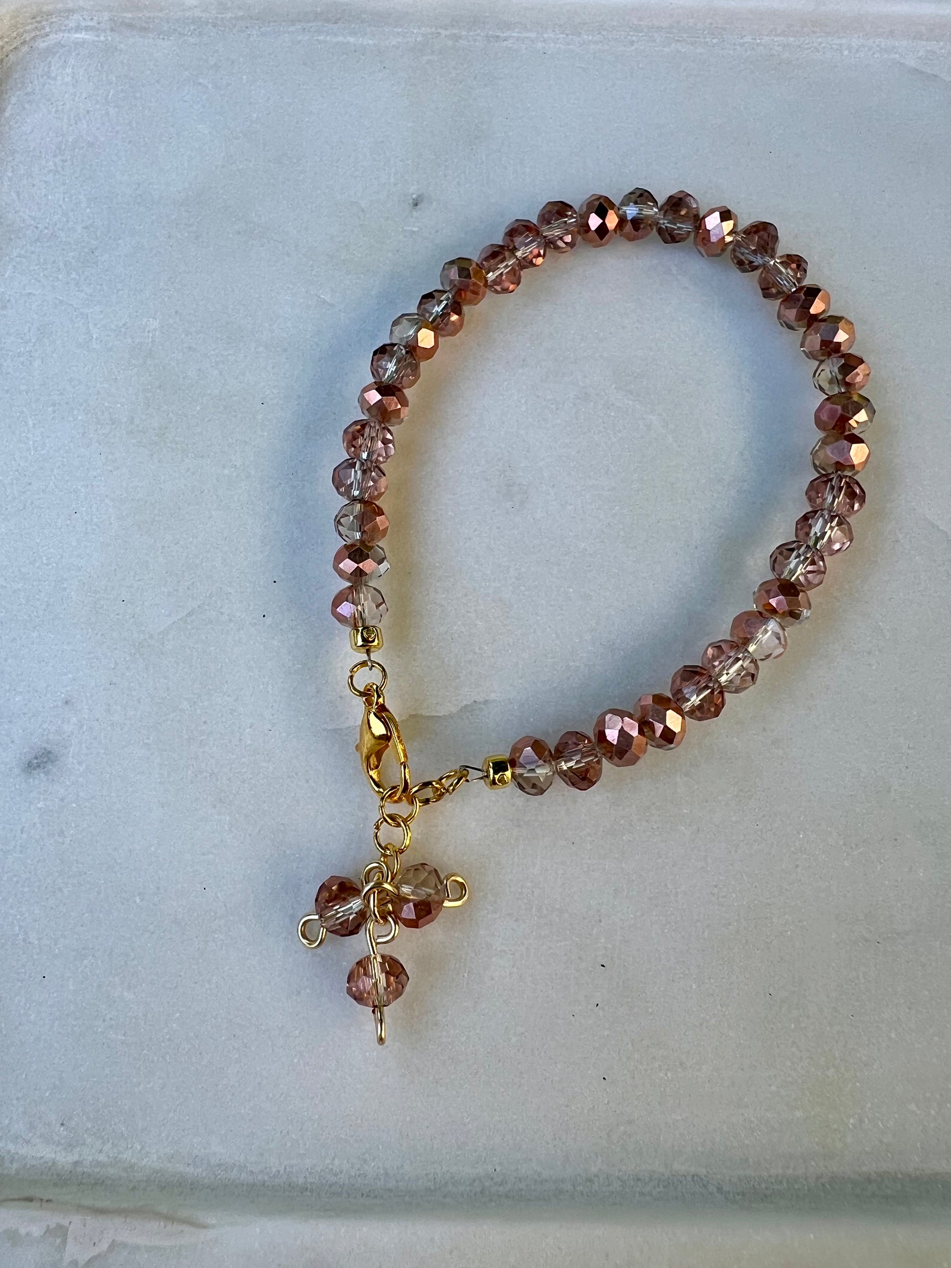 a beaded bracelet with a cross charm