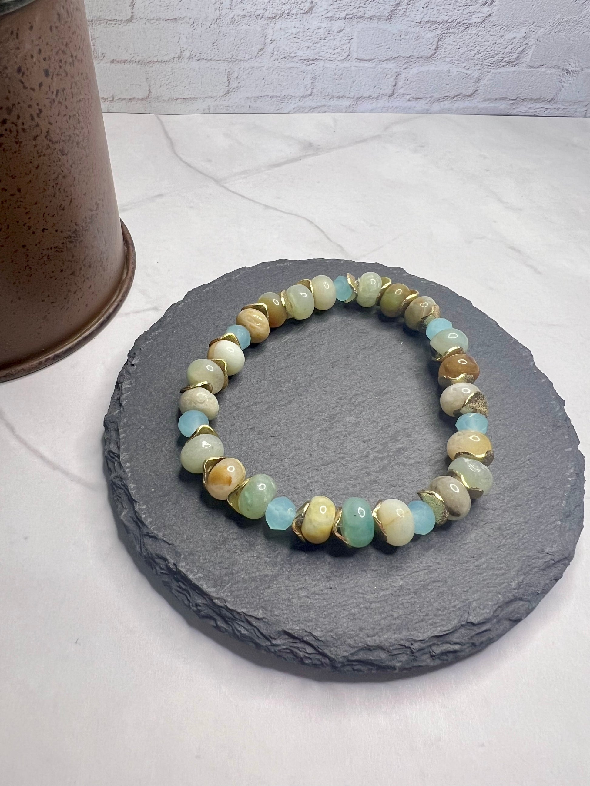 a stone bracelet with a green and yellow bead