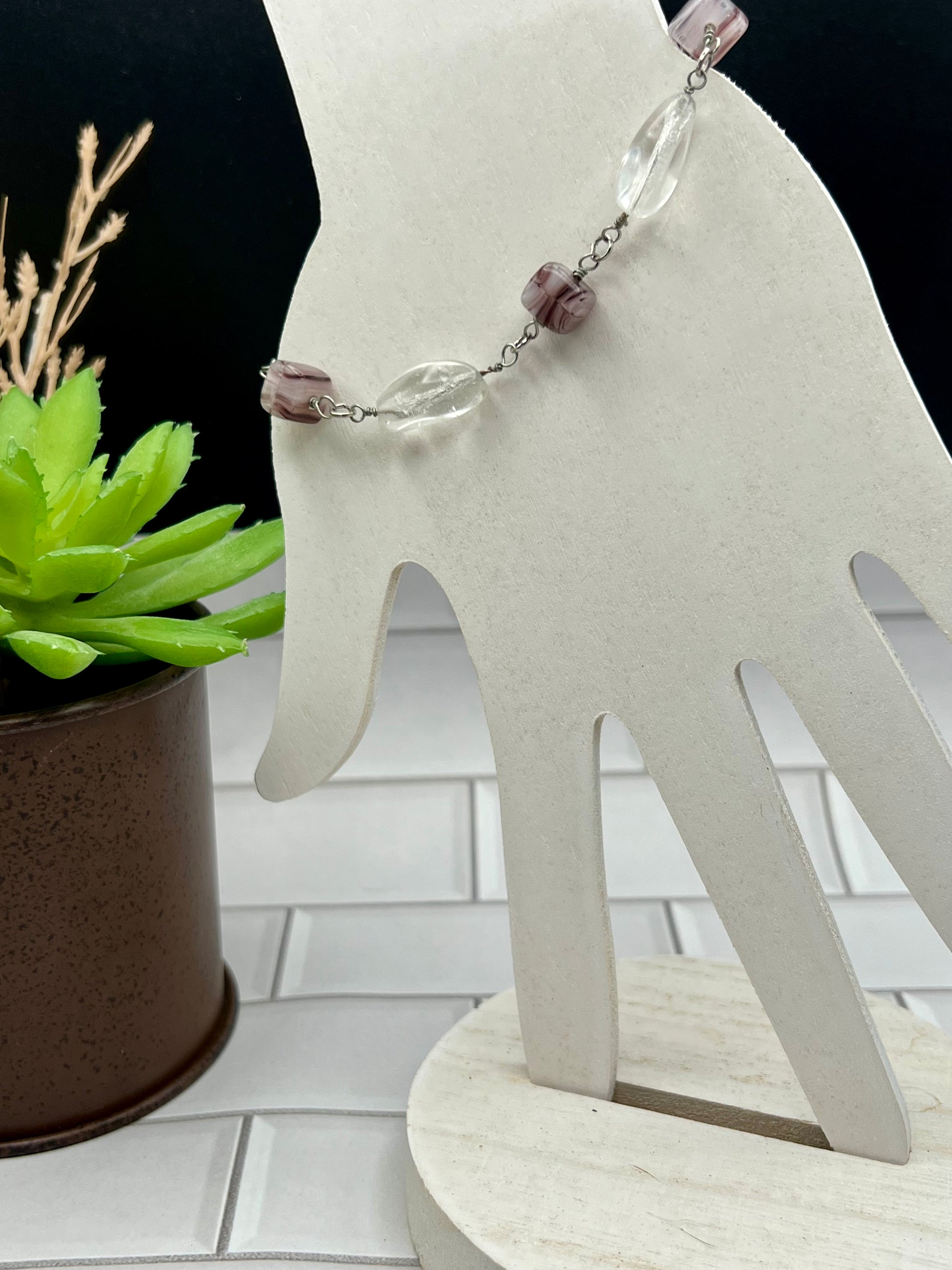 a white sculpture of a hand with a chain around it