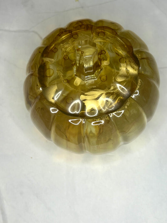 a yellow glass object sitting on top of a white table