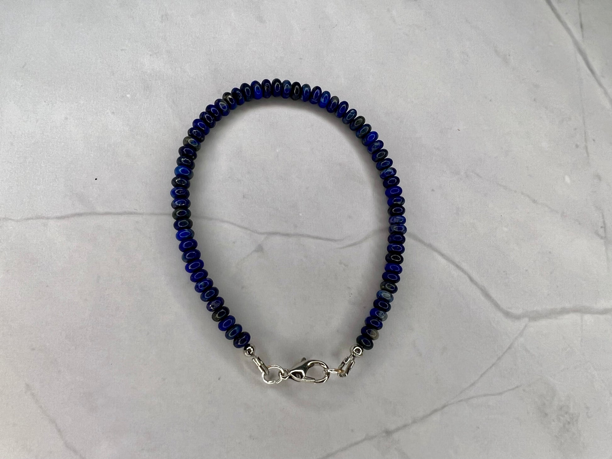 a blue beaded bracelet on a marble surface