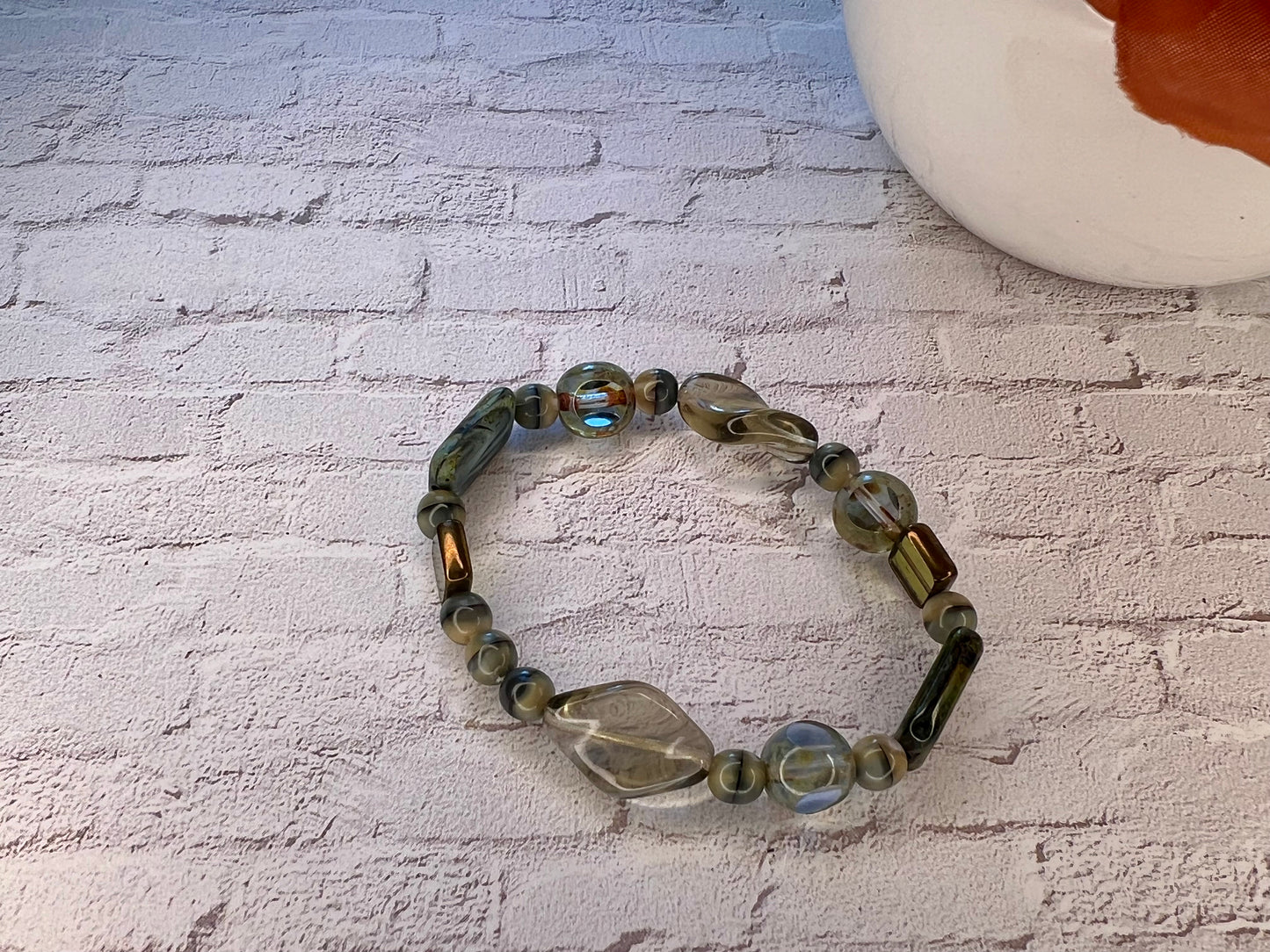 a bracelet made of glass beads on a brick wall