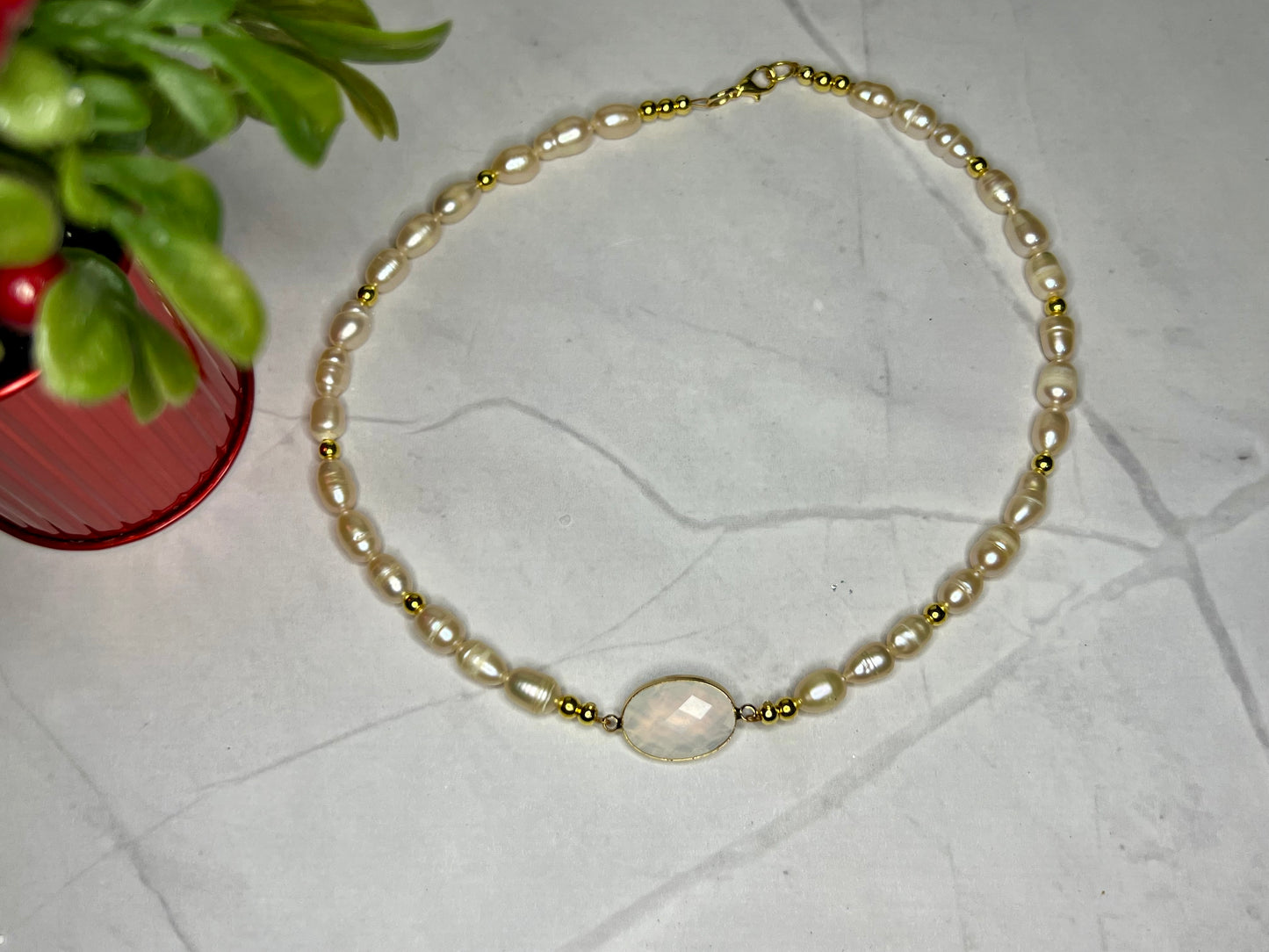 a bracelet with a white pearl and gold beads