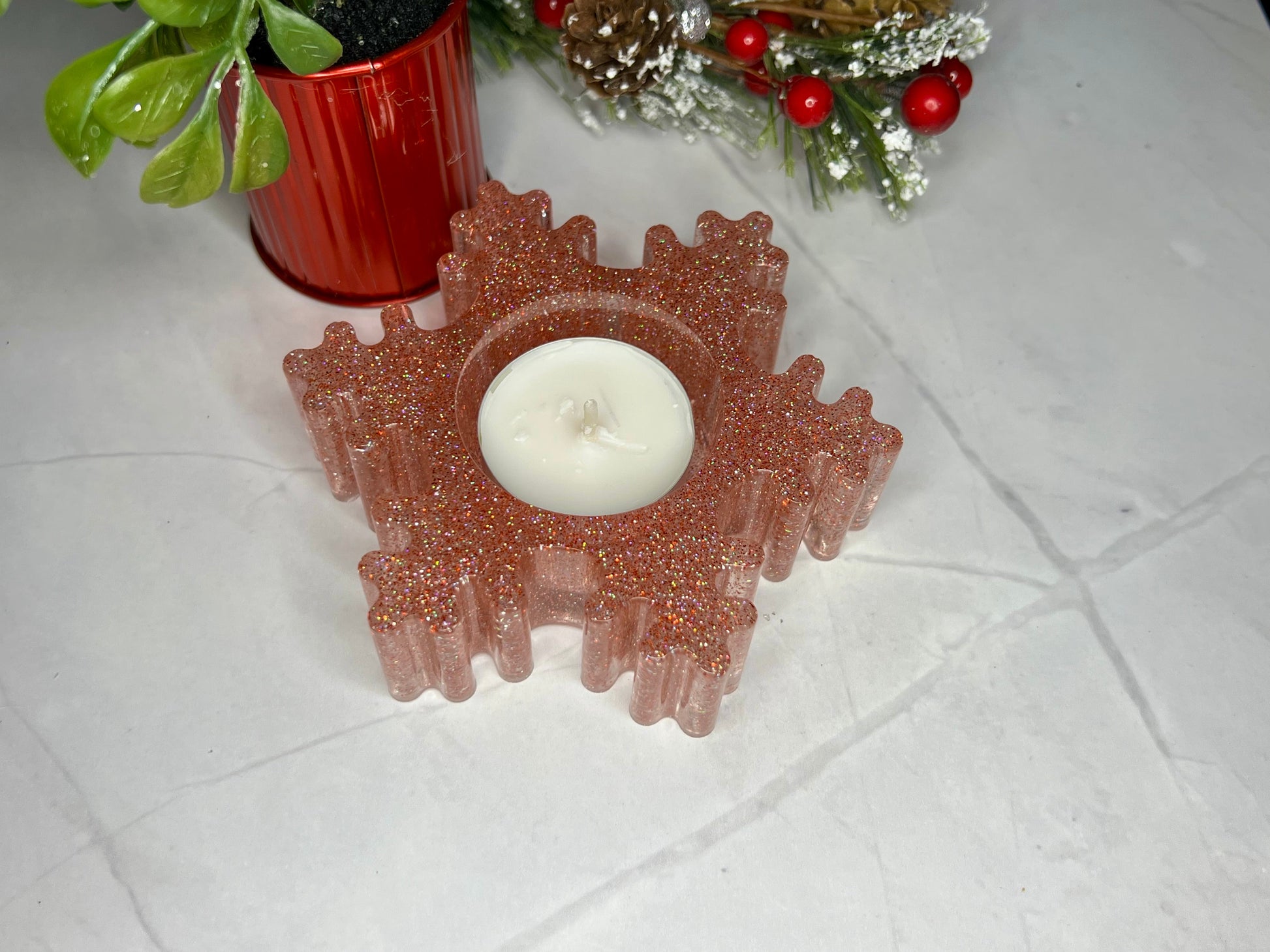 a candle sitting on a table next to a potted plant