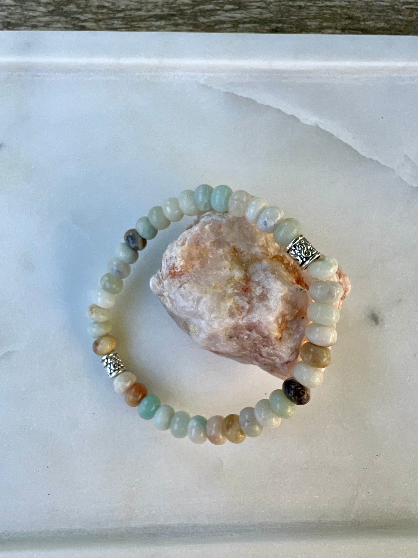 a beaded bracelet sitting on top of a rock