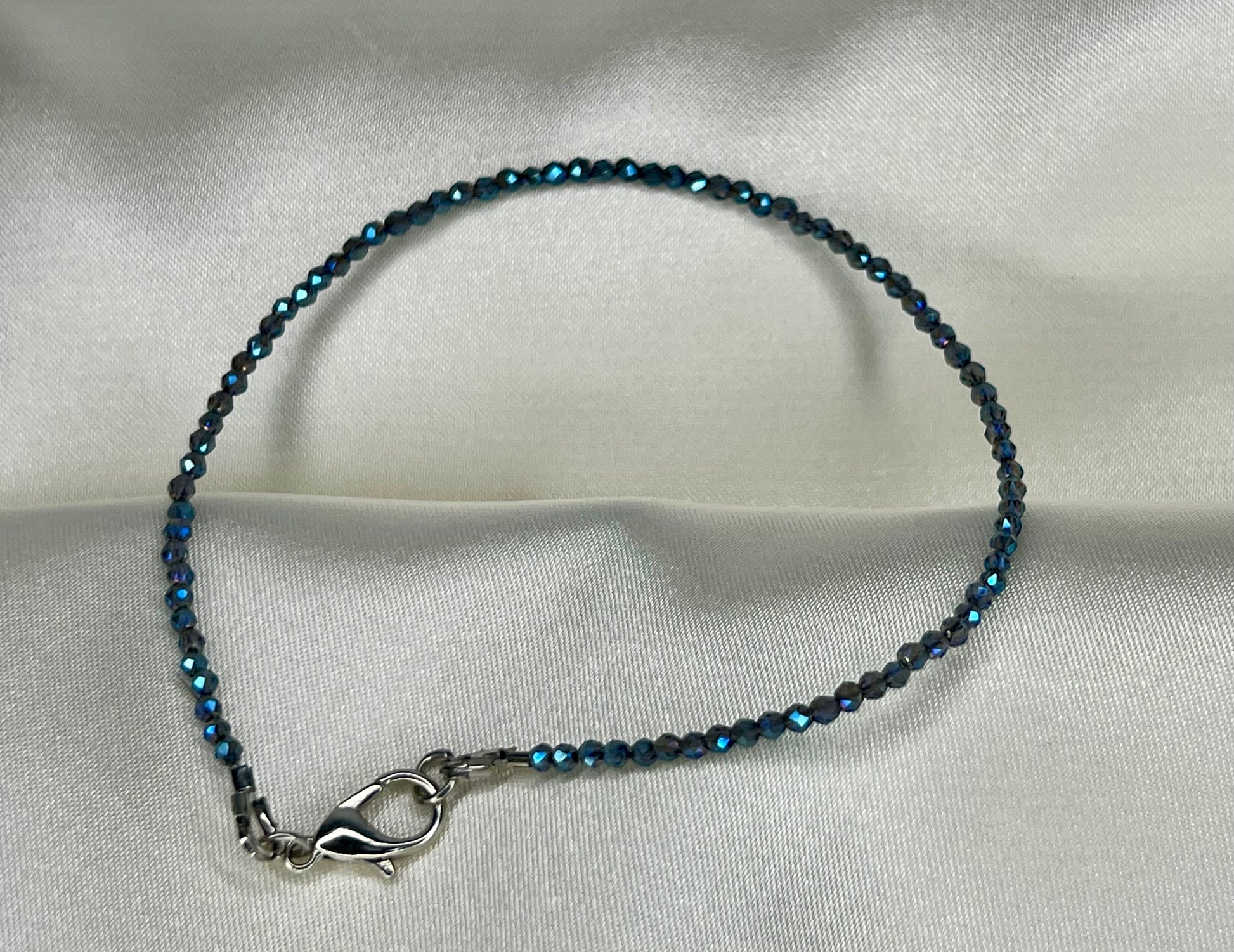 a blue beaded bracelet with a silver clasp