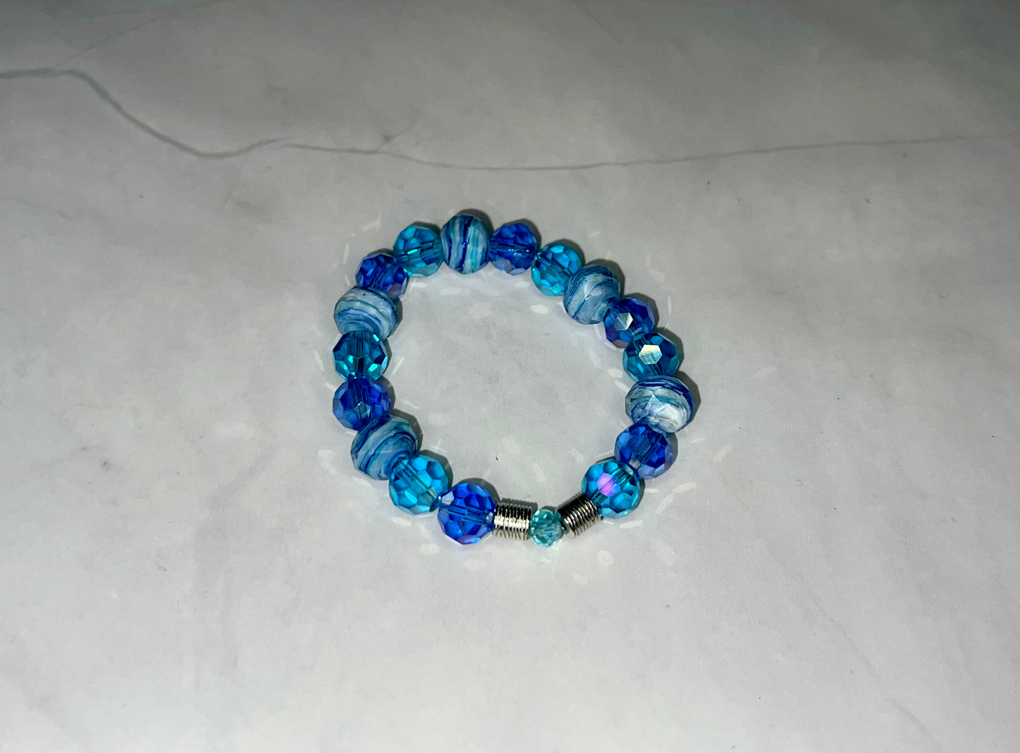 a blue beaded bracelet on a white surface