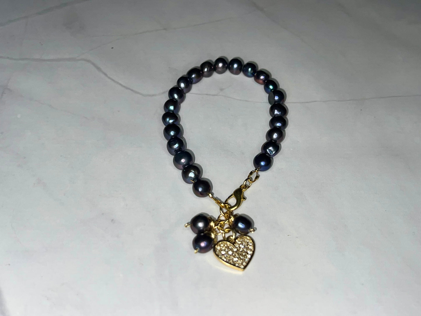 a black beaded bracelet with a heart charm