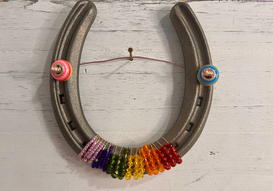 a horseshoe with a bunch of beads hanging from it