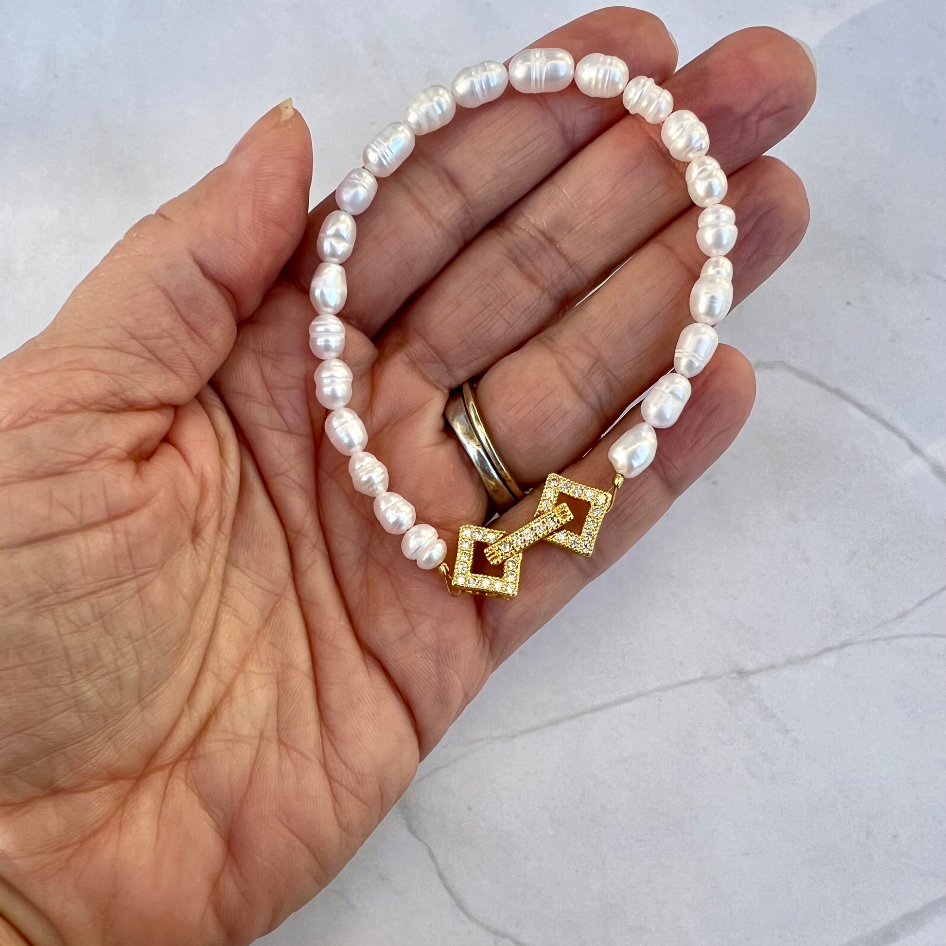 a person holding a bracelet with a cross on it