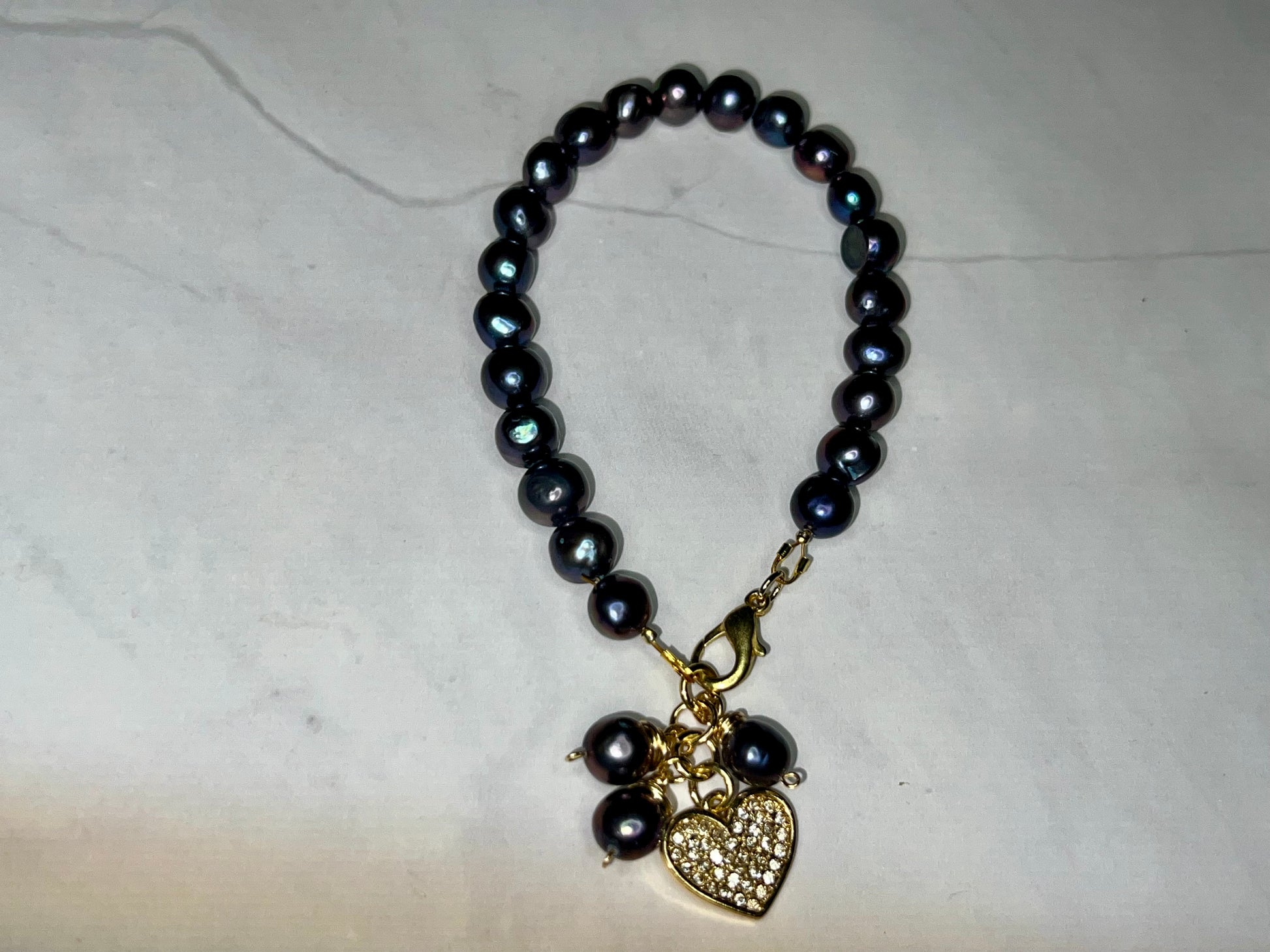 a black beaded necklace with a heart charm