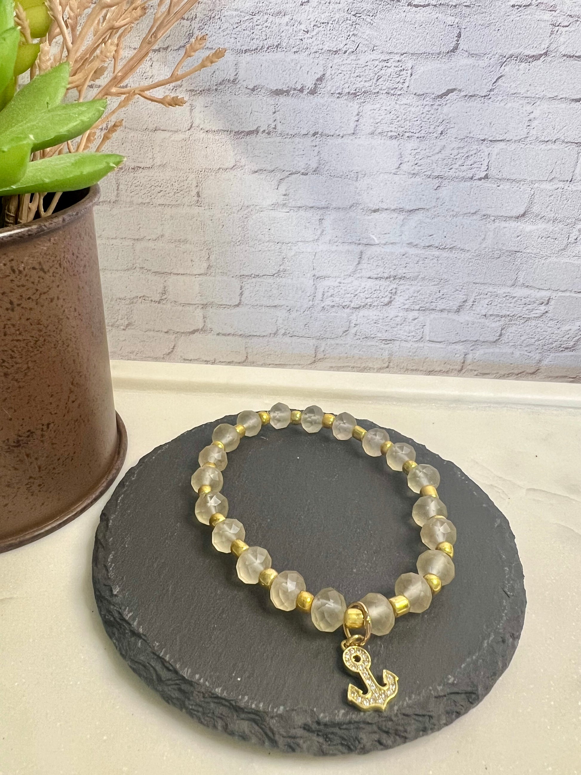 a yellow beaded bracelet with a gold initial charm