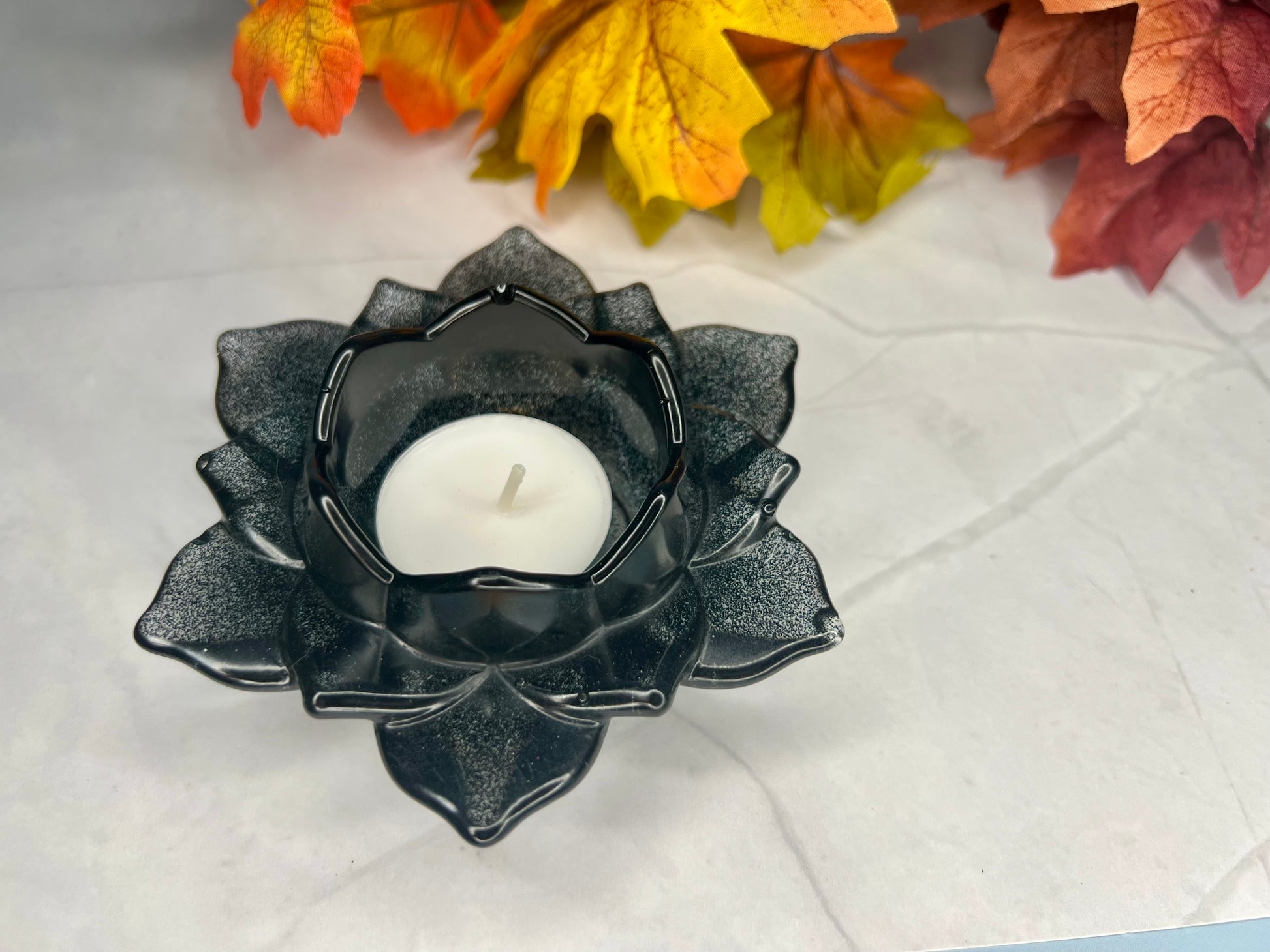 a black candle holder sitting on top of a table