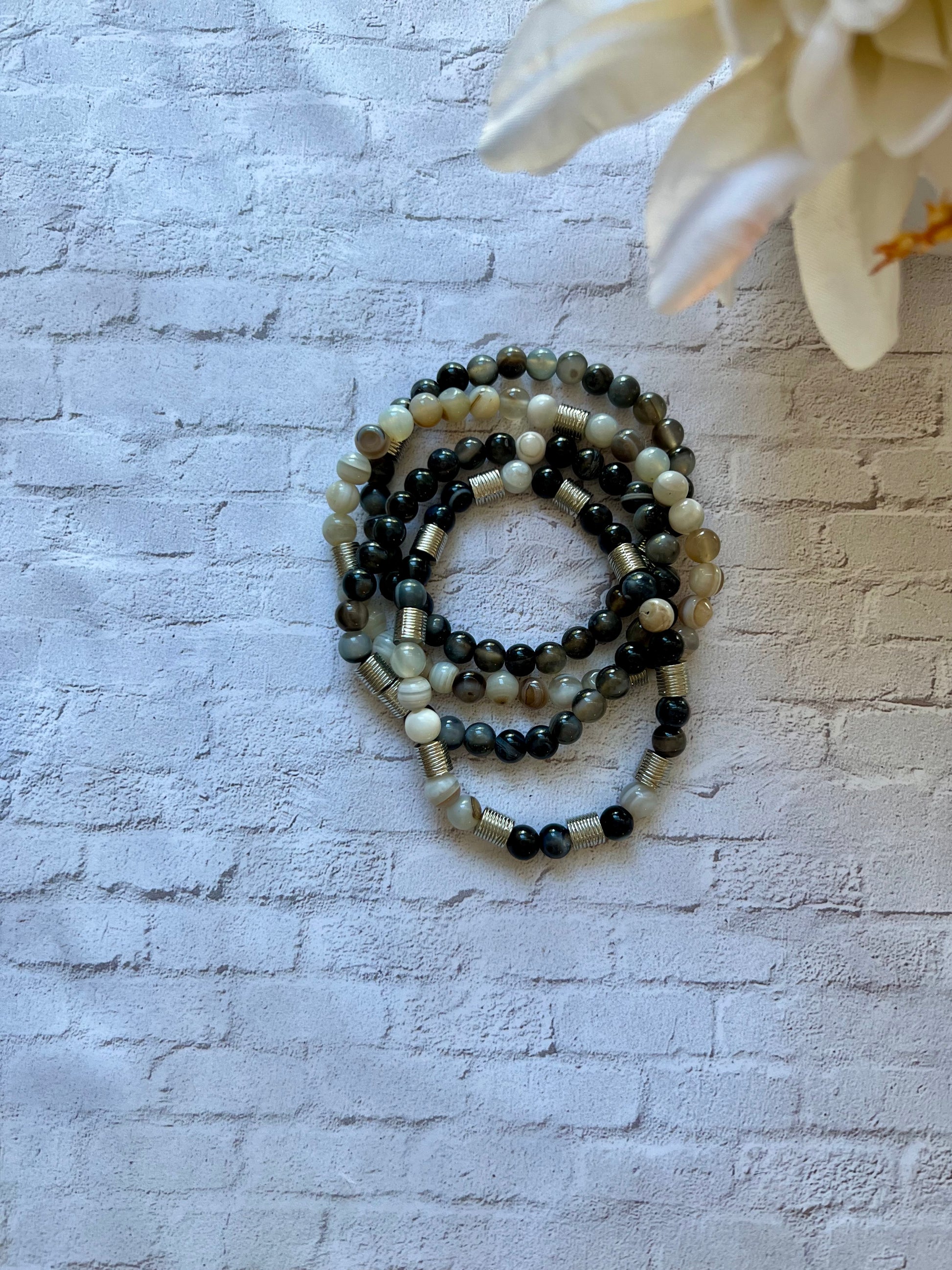 a white flower sitting next to a white brick wall