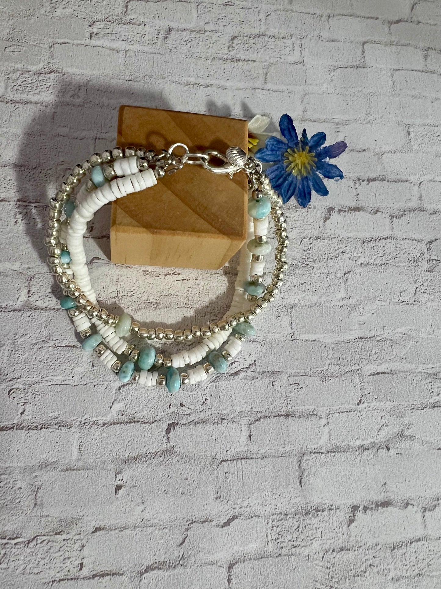 a white bracelet with a blue flower on it