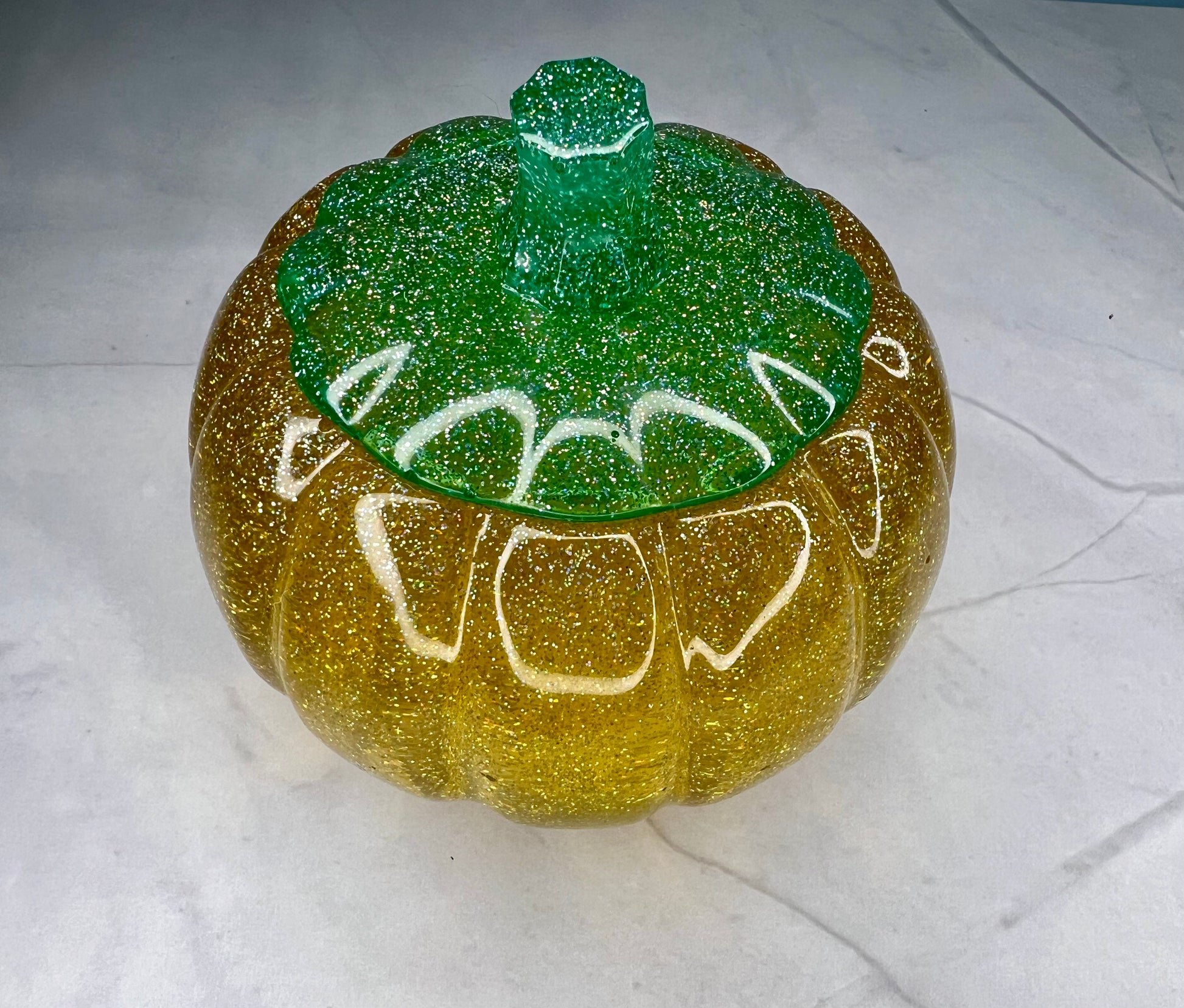 a green and yellow pumpkin with writing on it