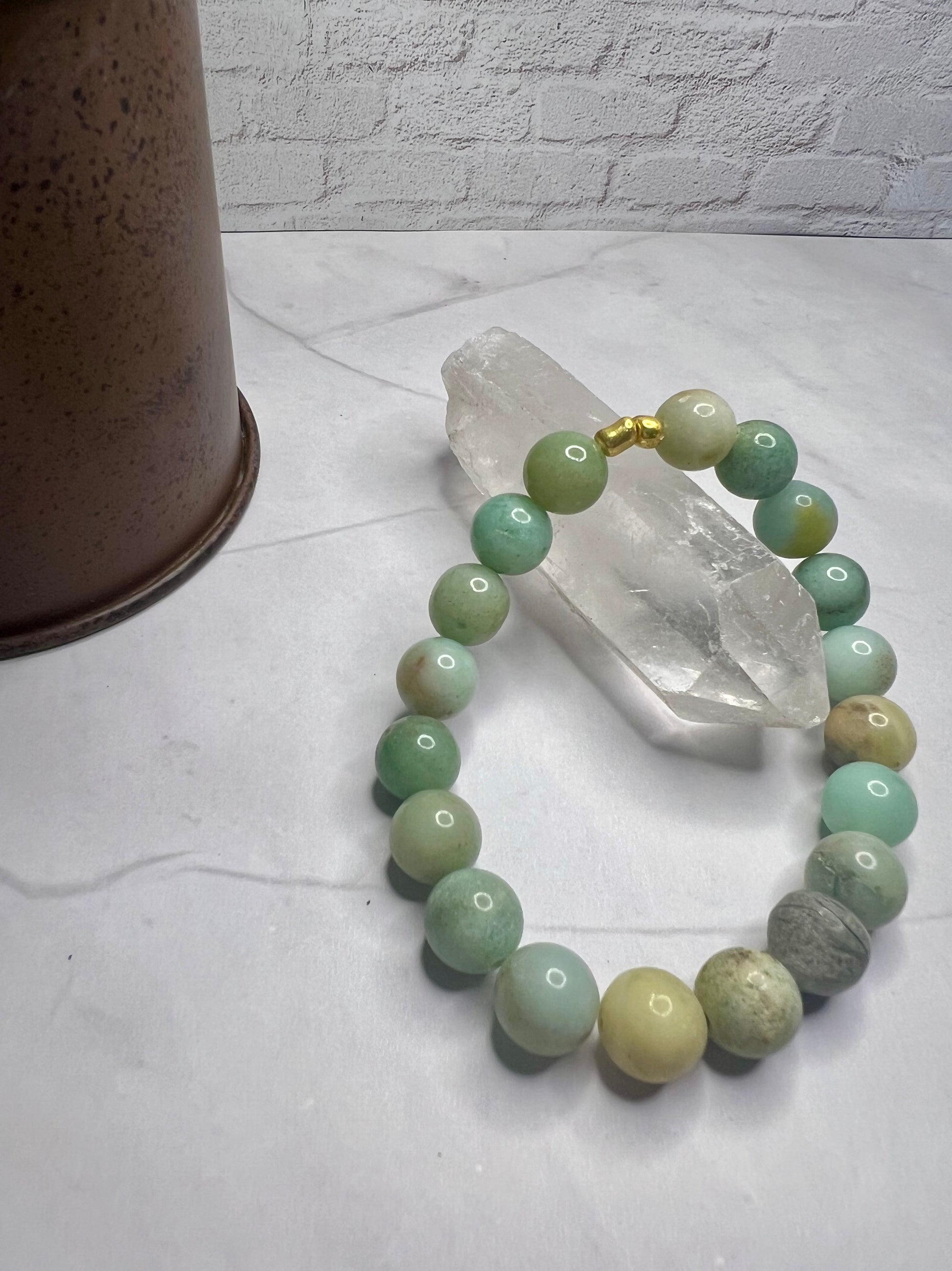 a bracelet with green and white beads on a table