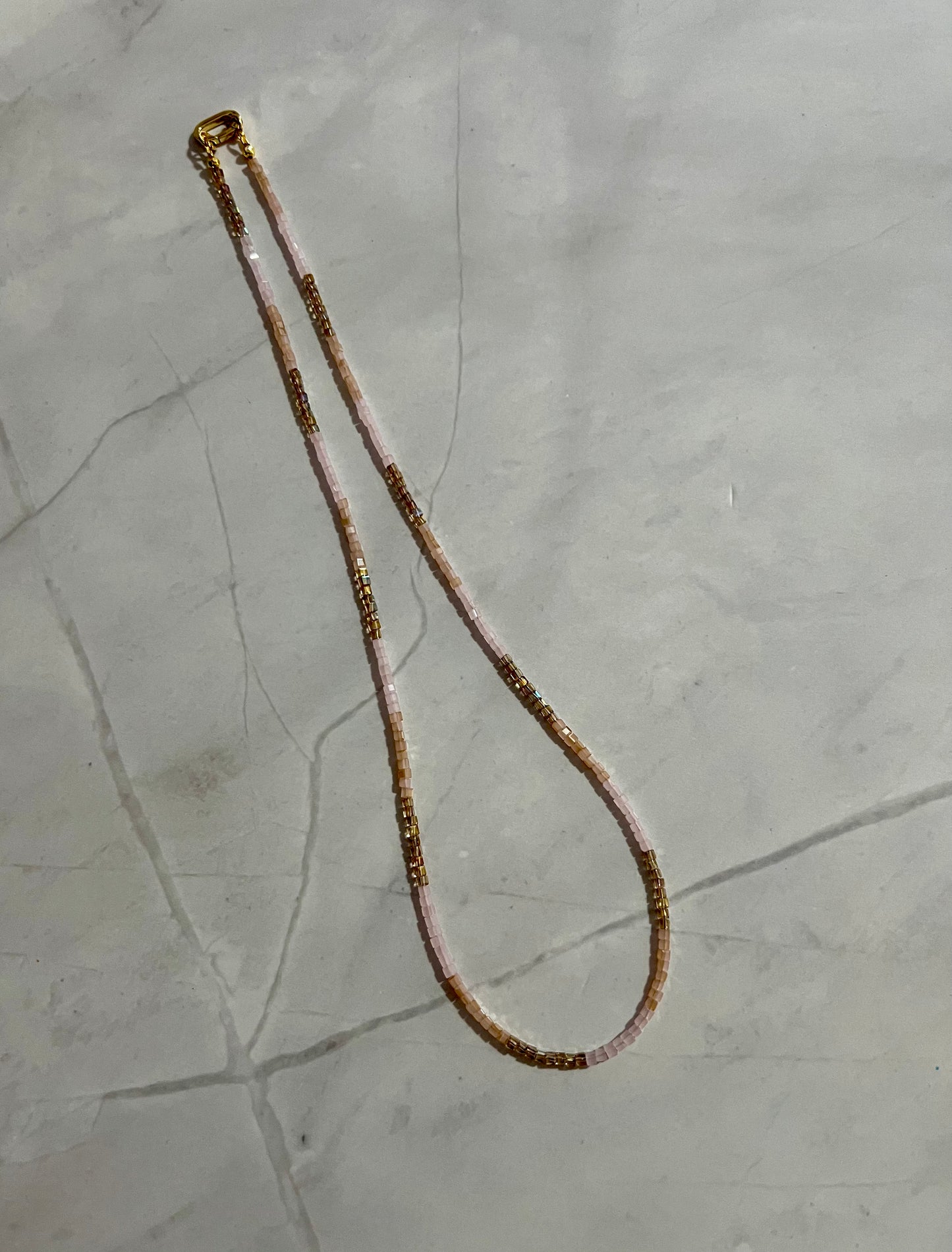 a long beaded necklace on a marble surface