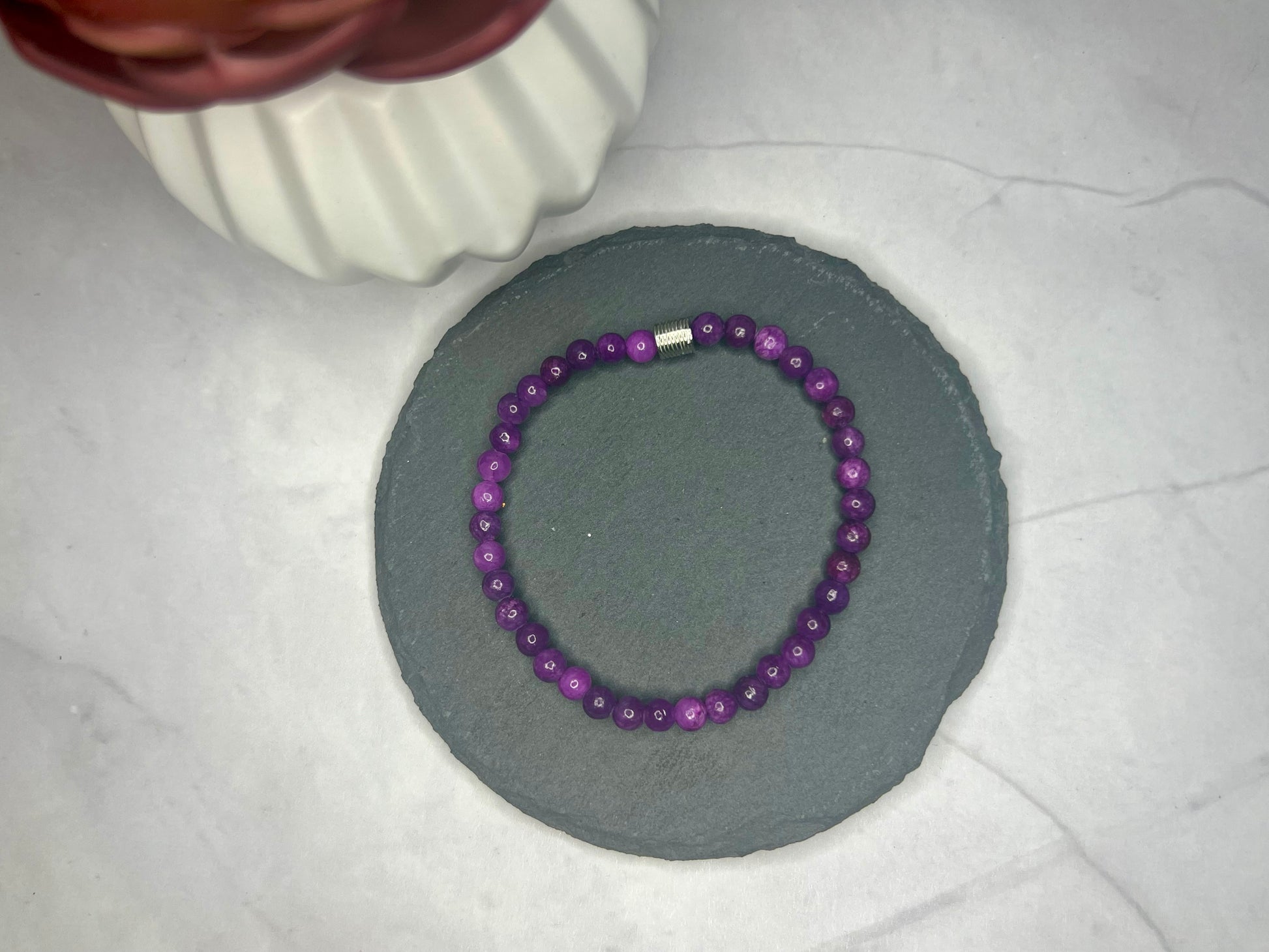 a purple beaded bracelet sitting on top of a table