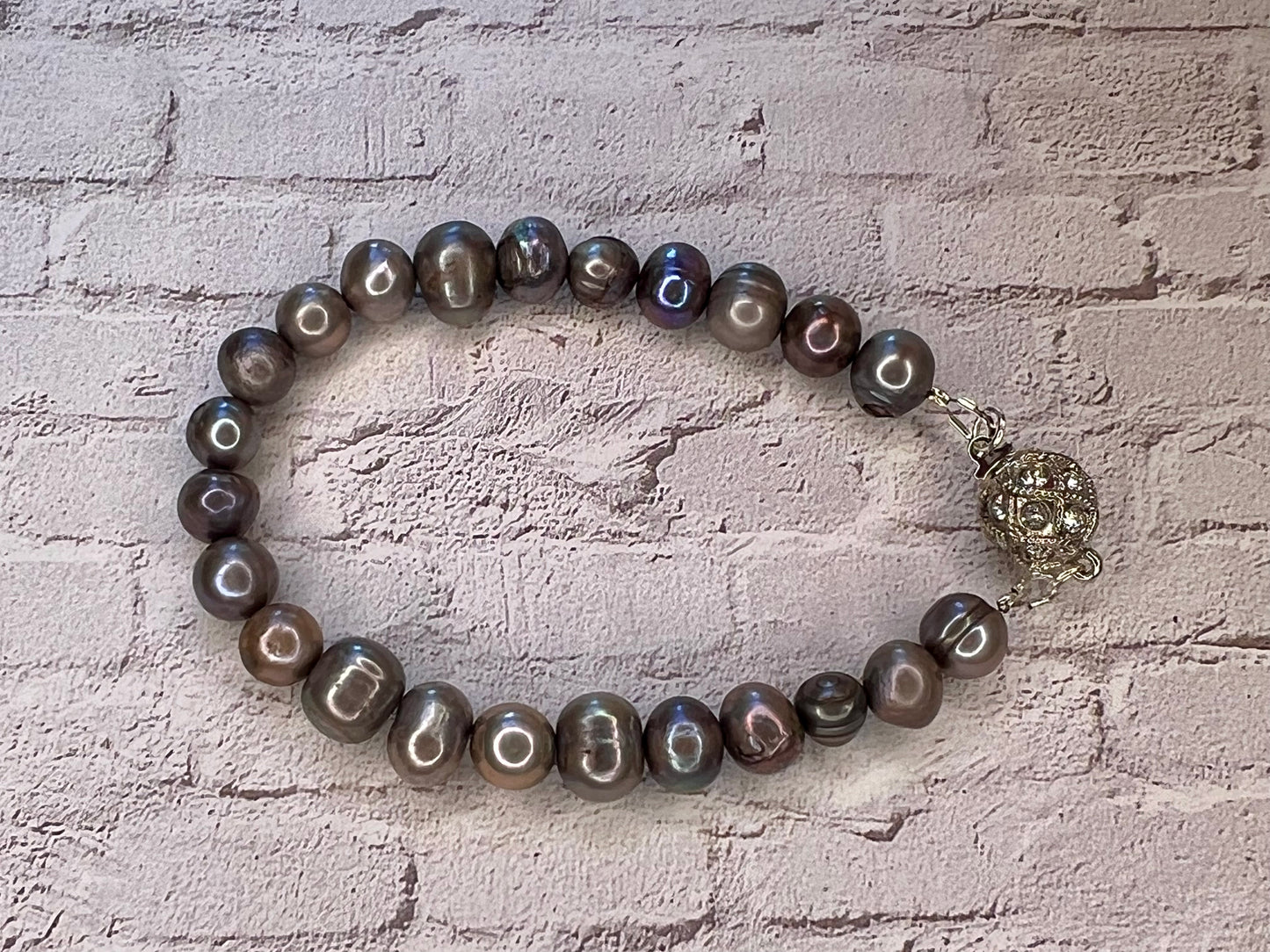 a bracelet with black pearls and a silver charm