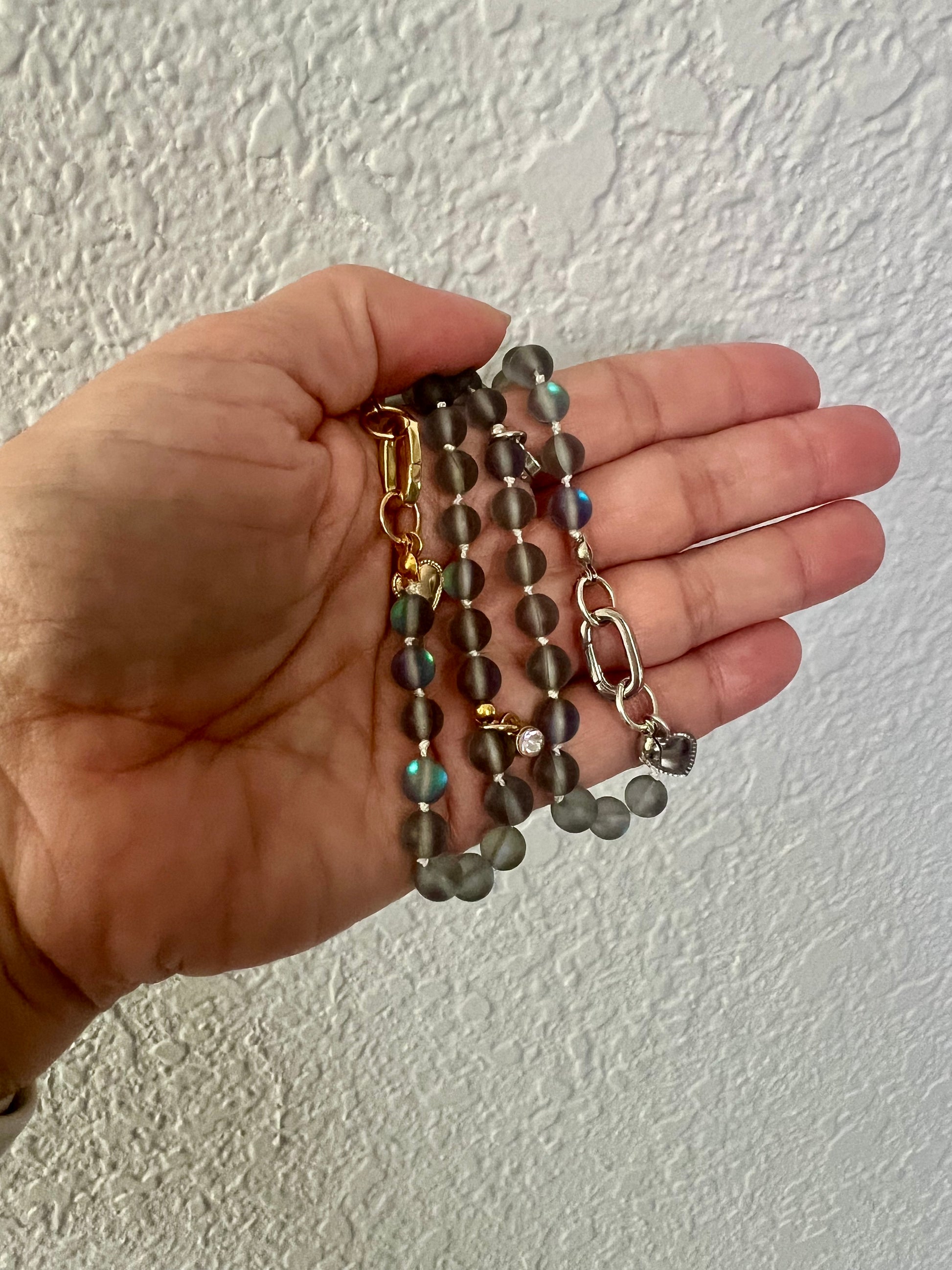 a hand holding a bunch of beads and a chain