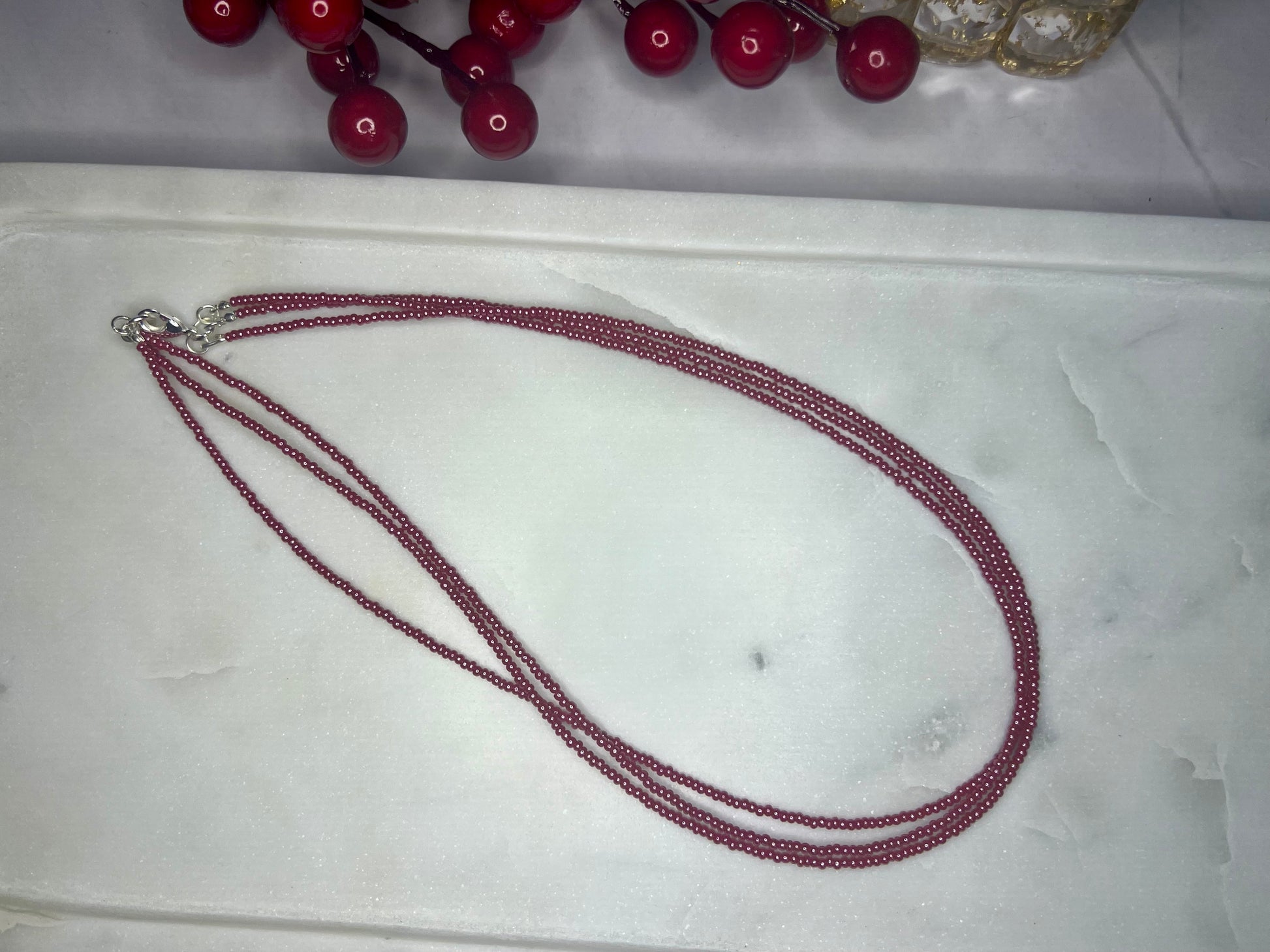 a red beaded necklace on a white tray