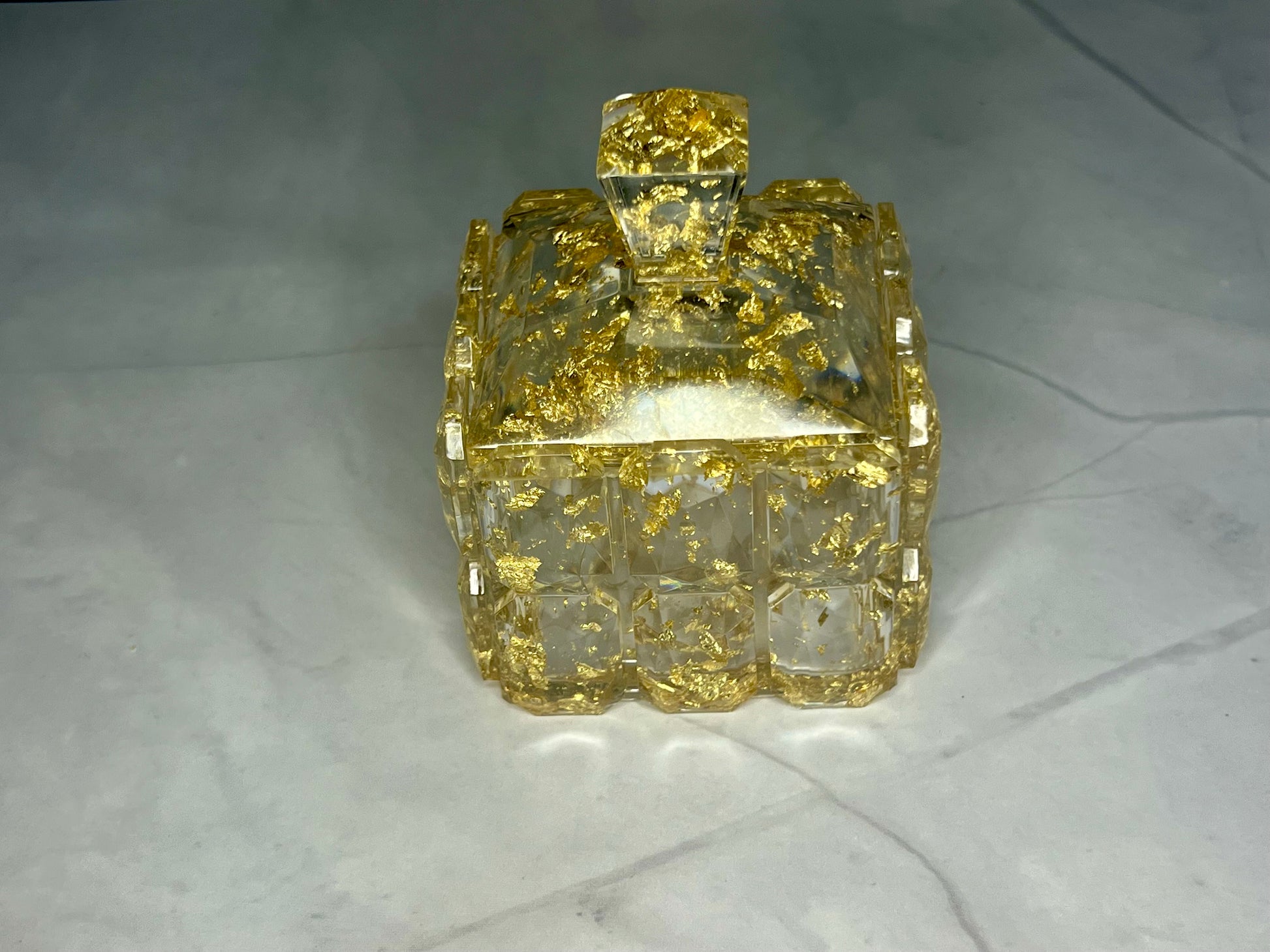 a glass box with a gold design on it