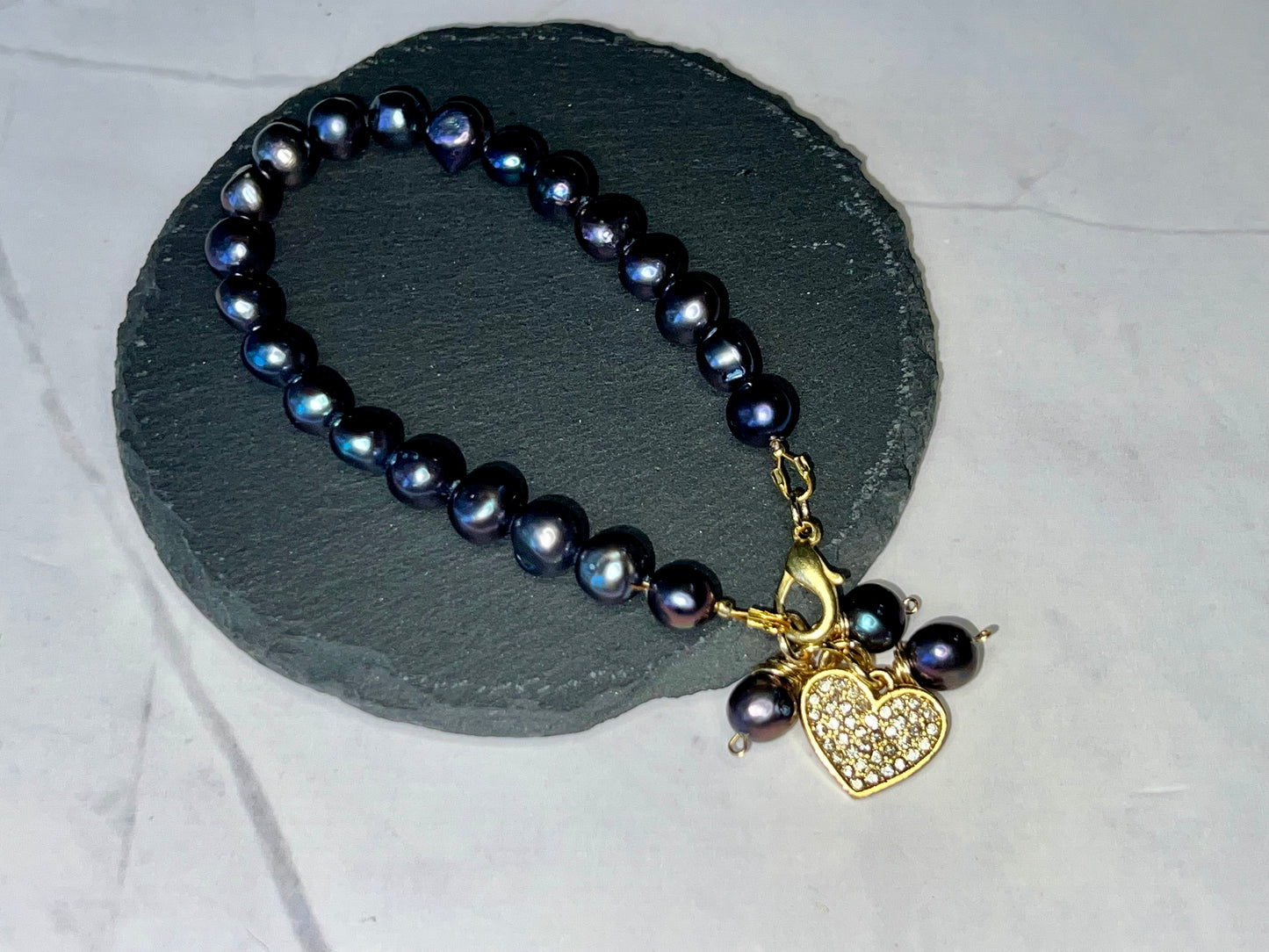 a black pearl necklace with a heart charm