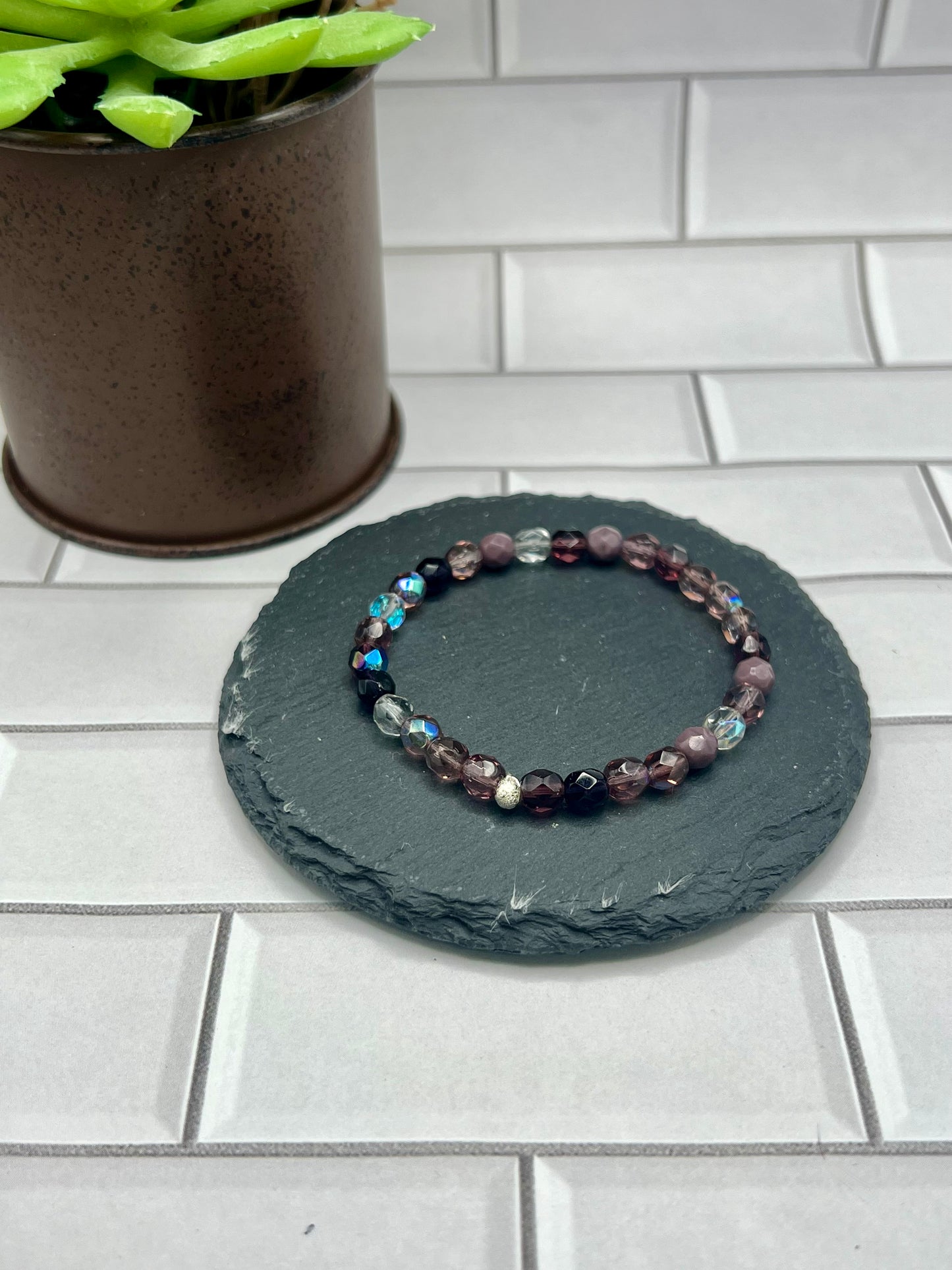 a stone with a beaded bracelet sitting on top of it