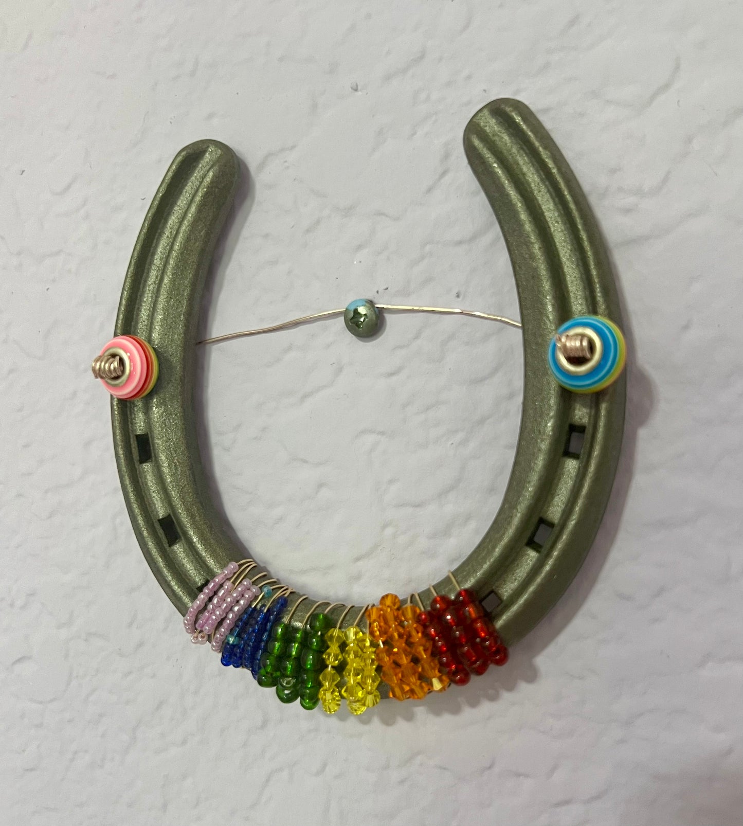 a horseshoe with a bunch of beads hanging from it