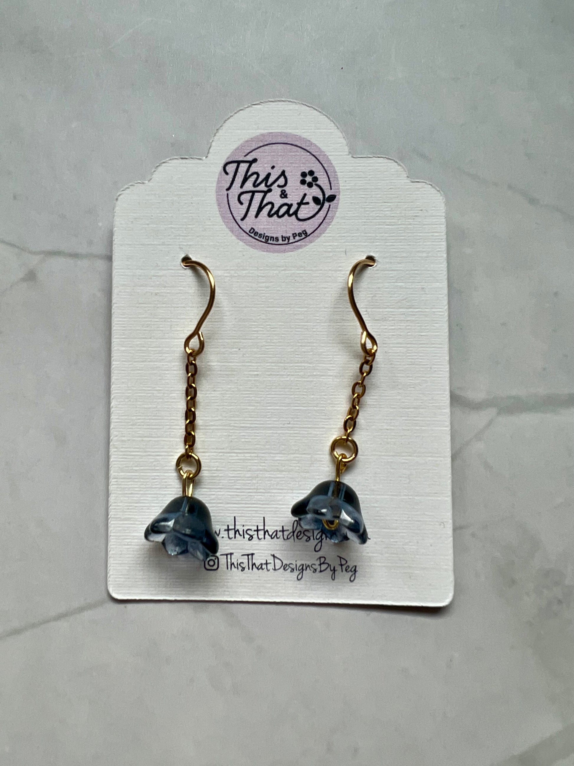 a pair of earrings with a dolphin on it