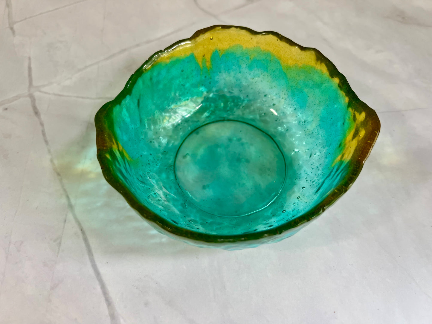 a green bowl sitting on top of a white table