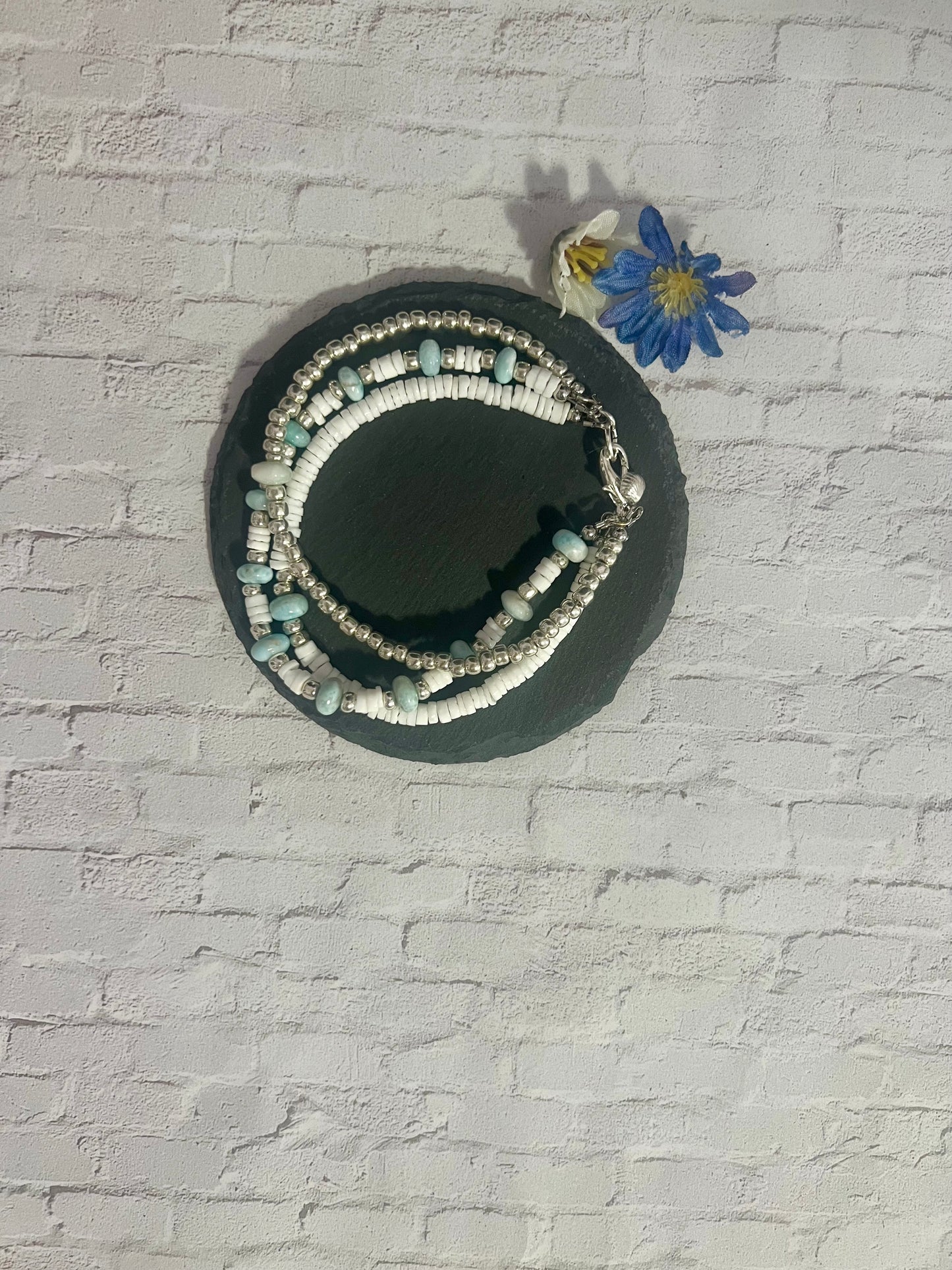 a white brick wall with a blue flower on it