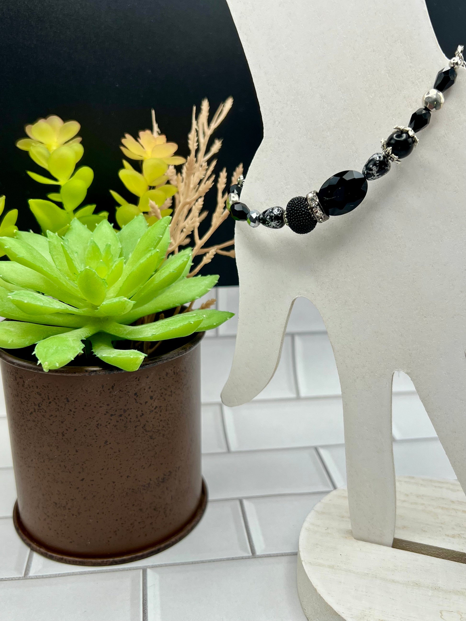 a plant with a black bead necklace on it