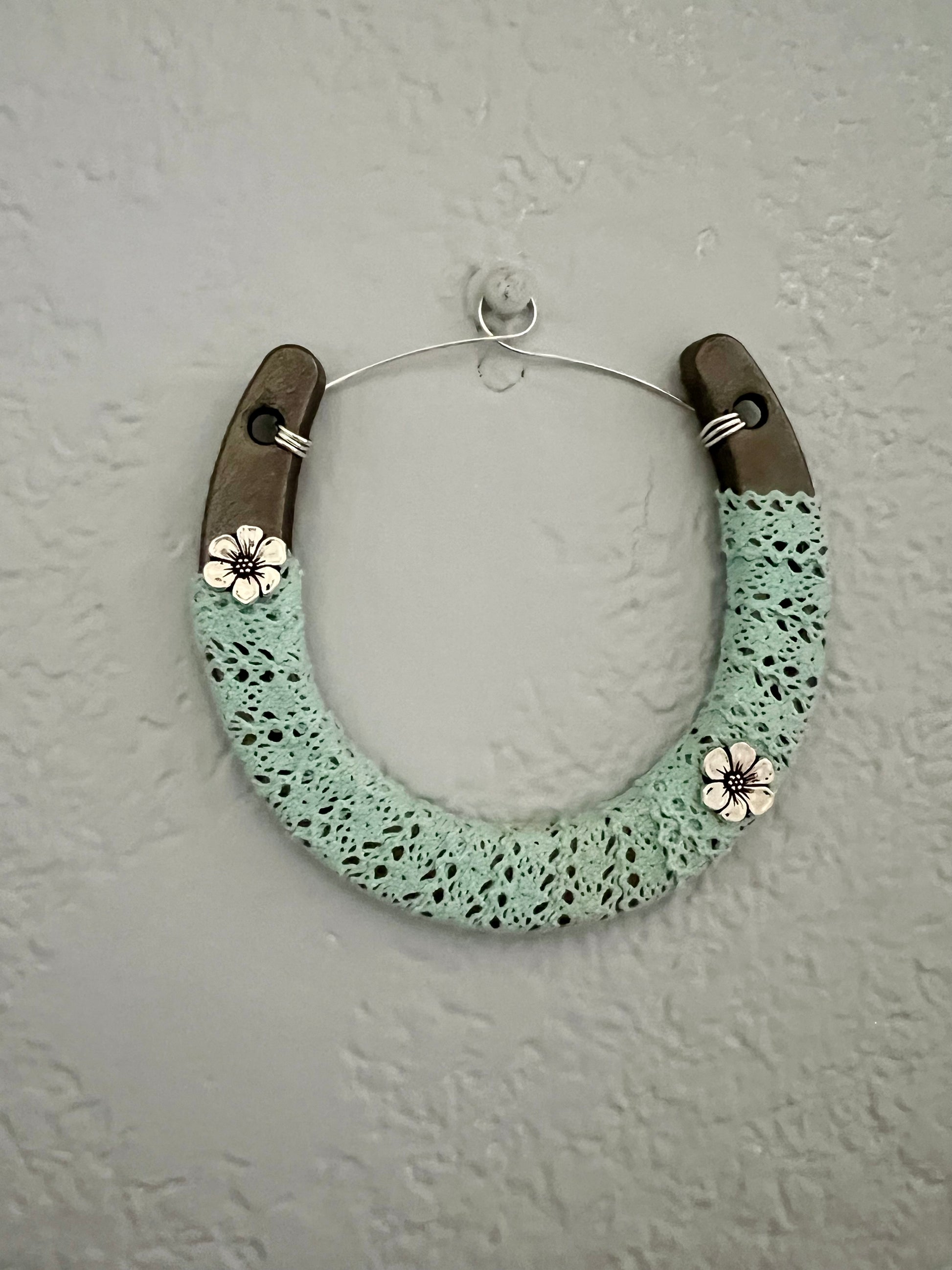 a green and brown bracelet hanging on a wall