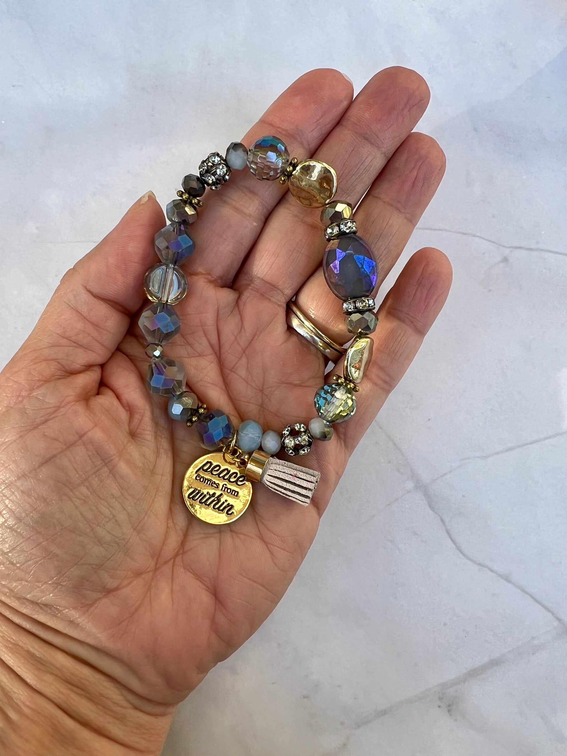 a woman's hand holding a bracelet with charms