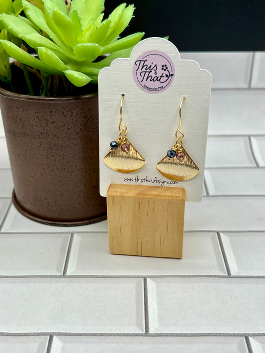 a pair of earrings sitting next to a potted plant