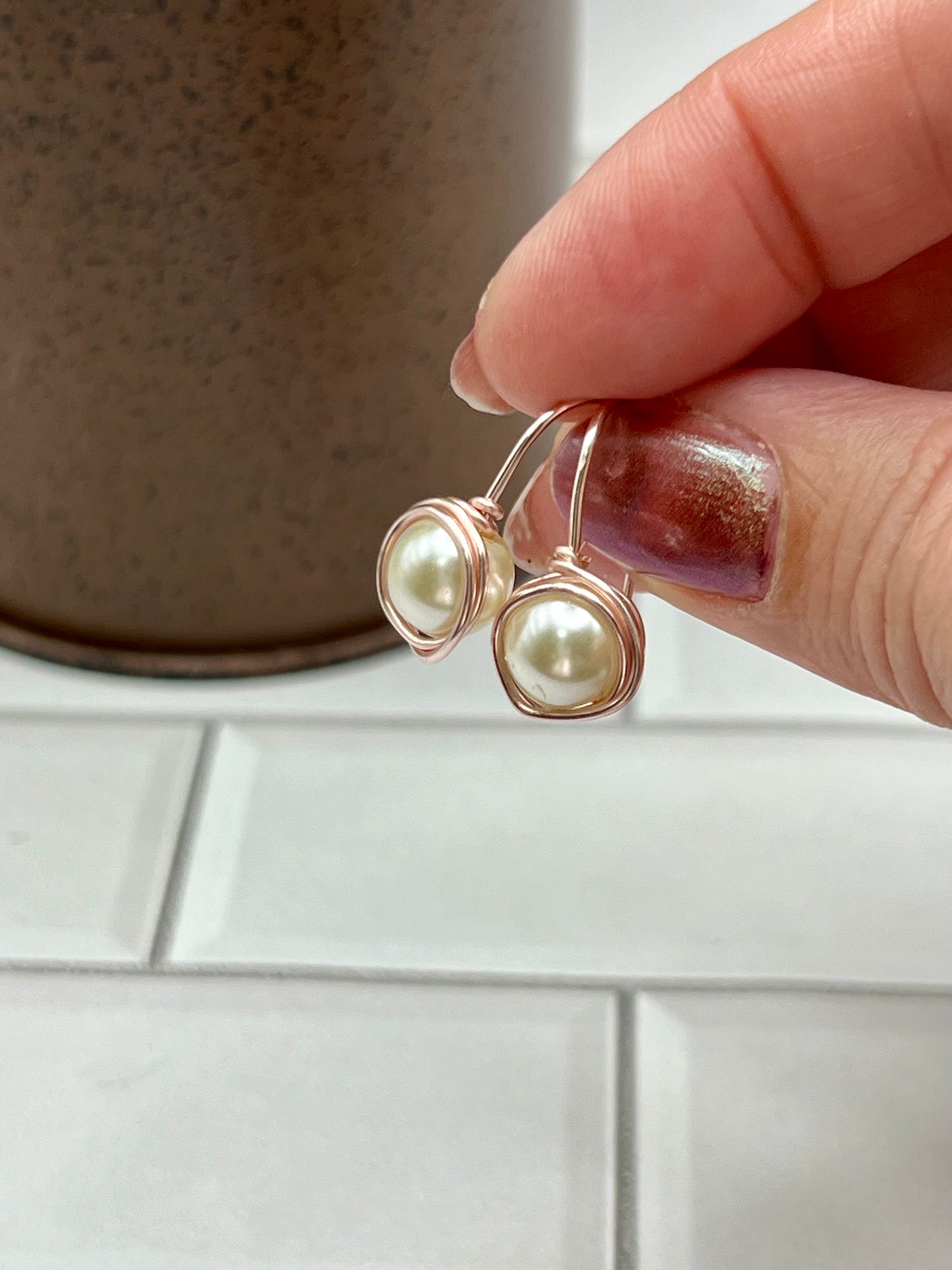 a person holding a pair of earrings in their hand